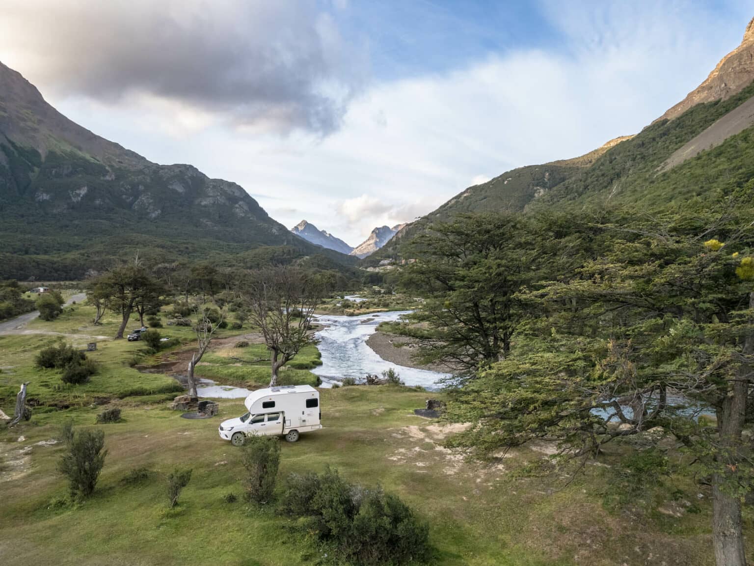 Ein Campertruck in einem Bergtal mit Fluss auf Feuerland.