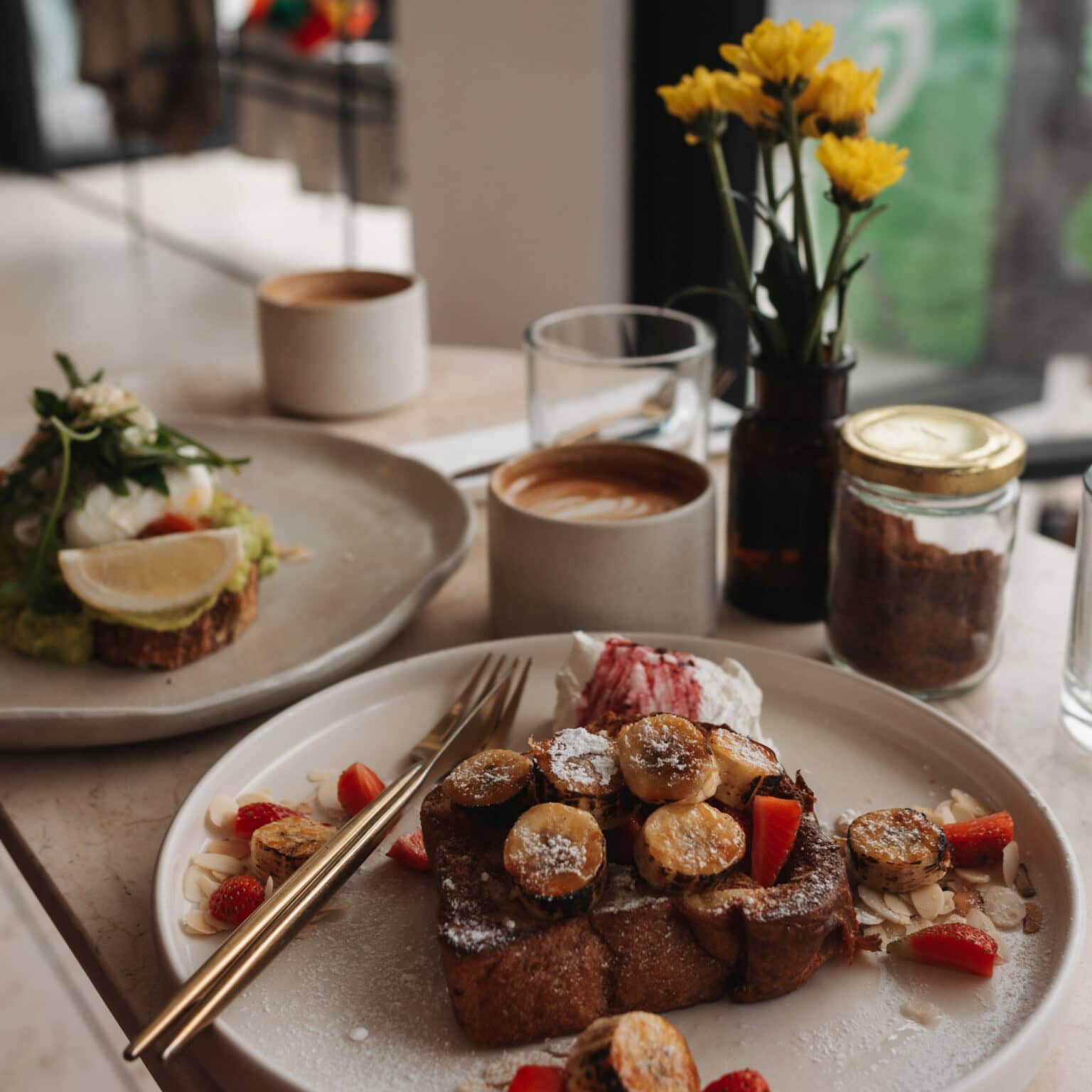Ein Frühstückstisch im Touche Cafe auf Bali mit French Toast und Avocado Toast.