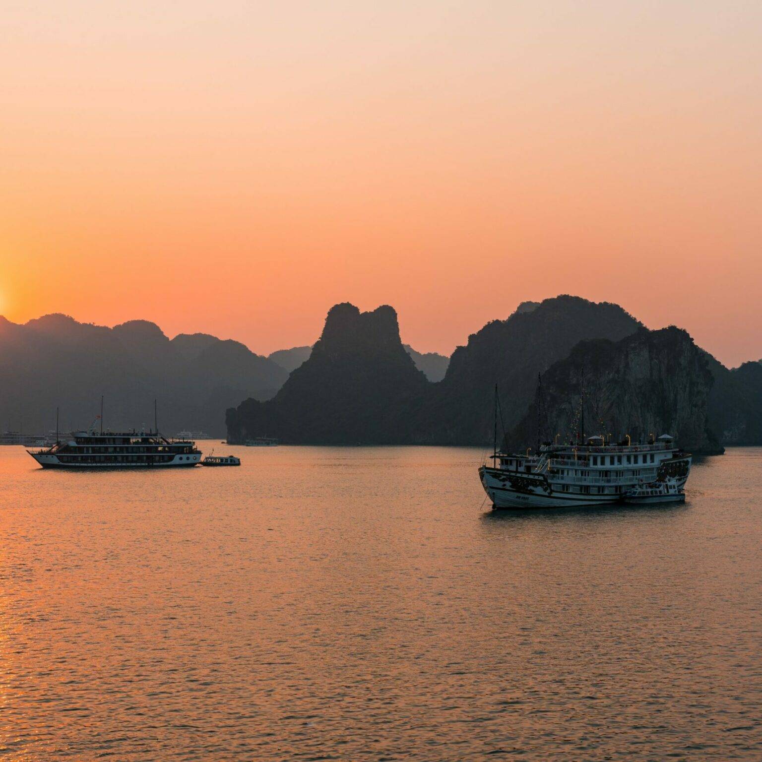 Zwei Schiffe im Abendlicht in der Halong-Bucht.