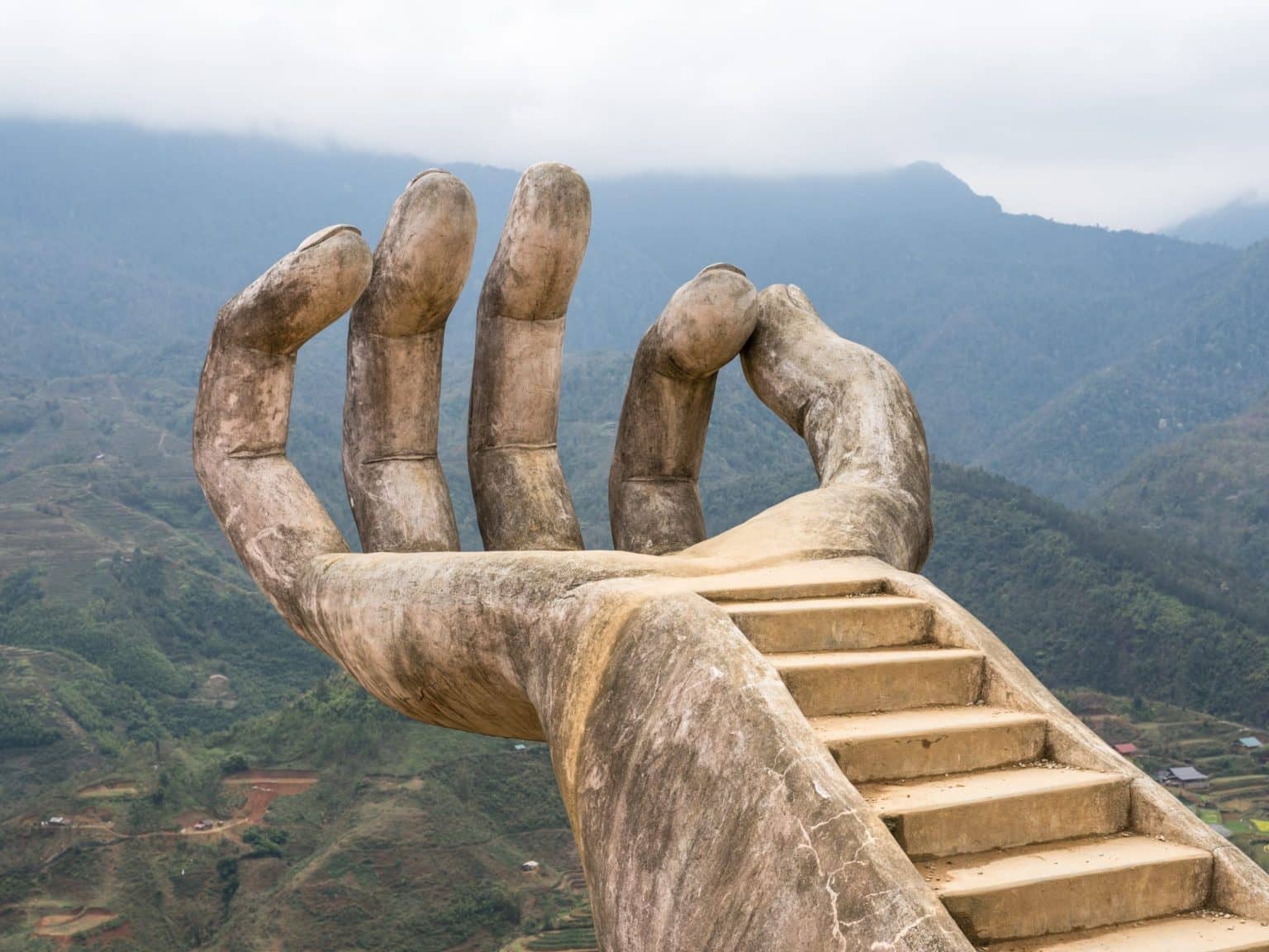 Eine riesige steinerne Hand mit eingebauter Treppe auf dem Areal des Café-Restaurants Moana.
