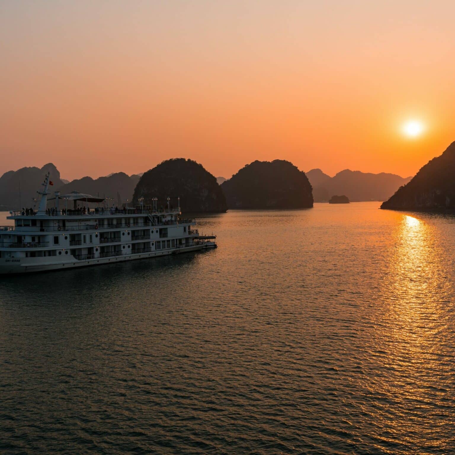 Ein Kreuzfahrschiff im Abendlicht in der Halong-Bucht.