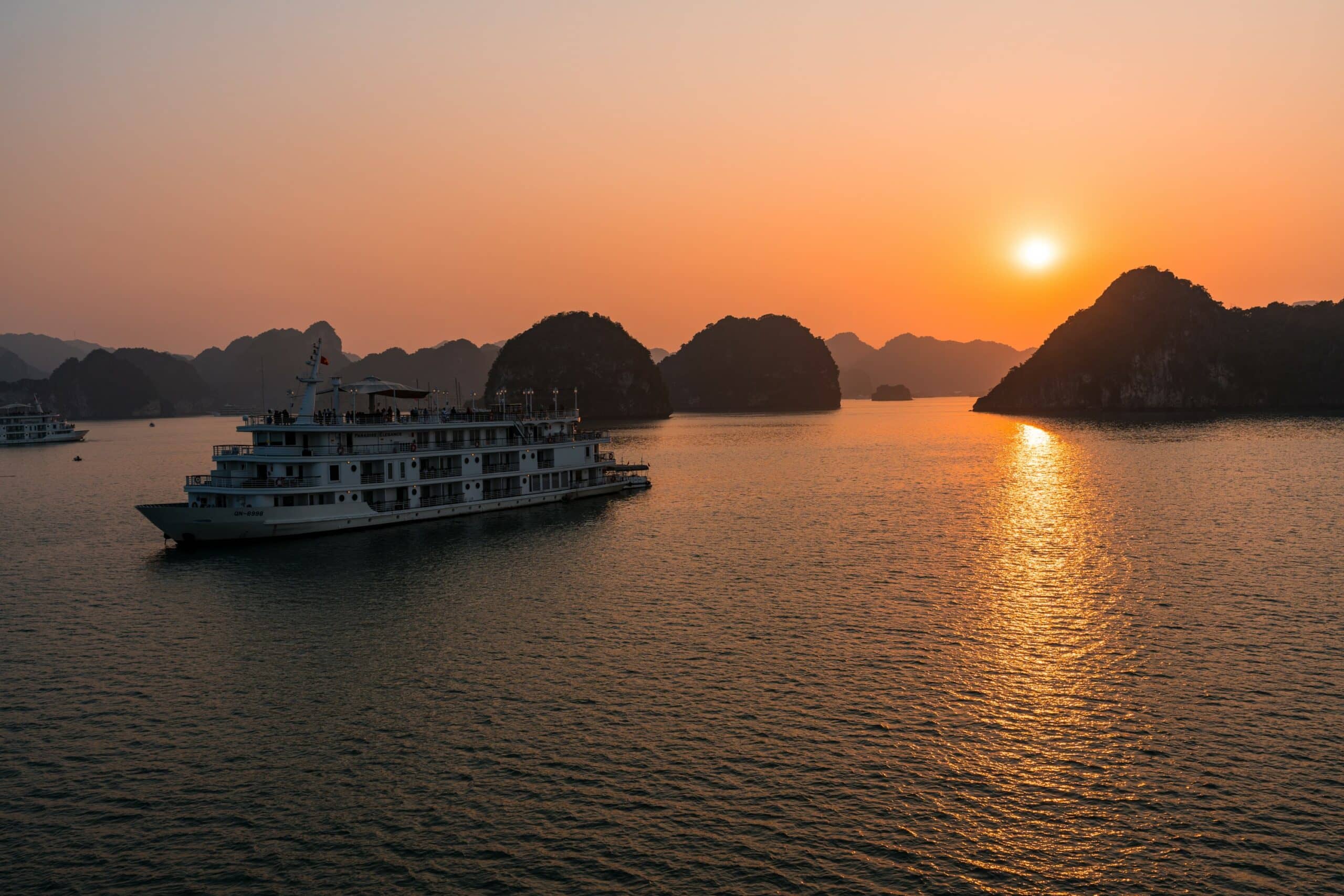 Ein Kreuzfahrschiff im Abendlicht in der Halong-Bucht.
