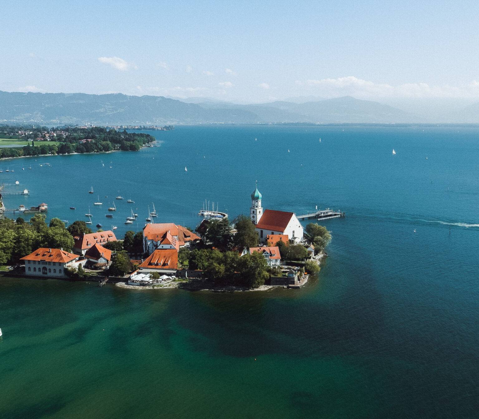 Die Wasserburg auf einer Halbinsel am Bodensee aus der Vogelperspektive.