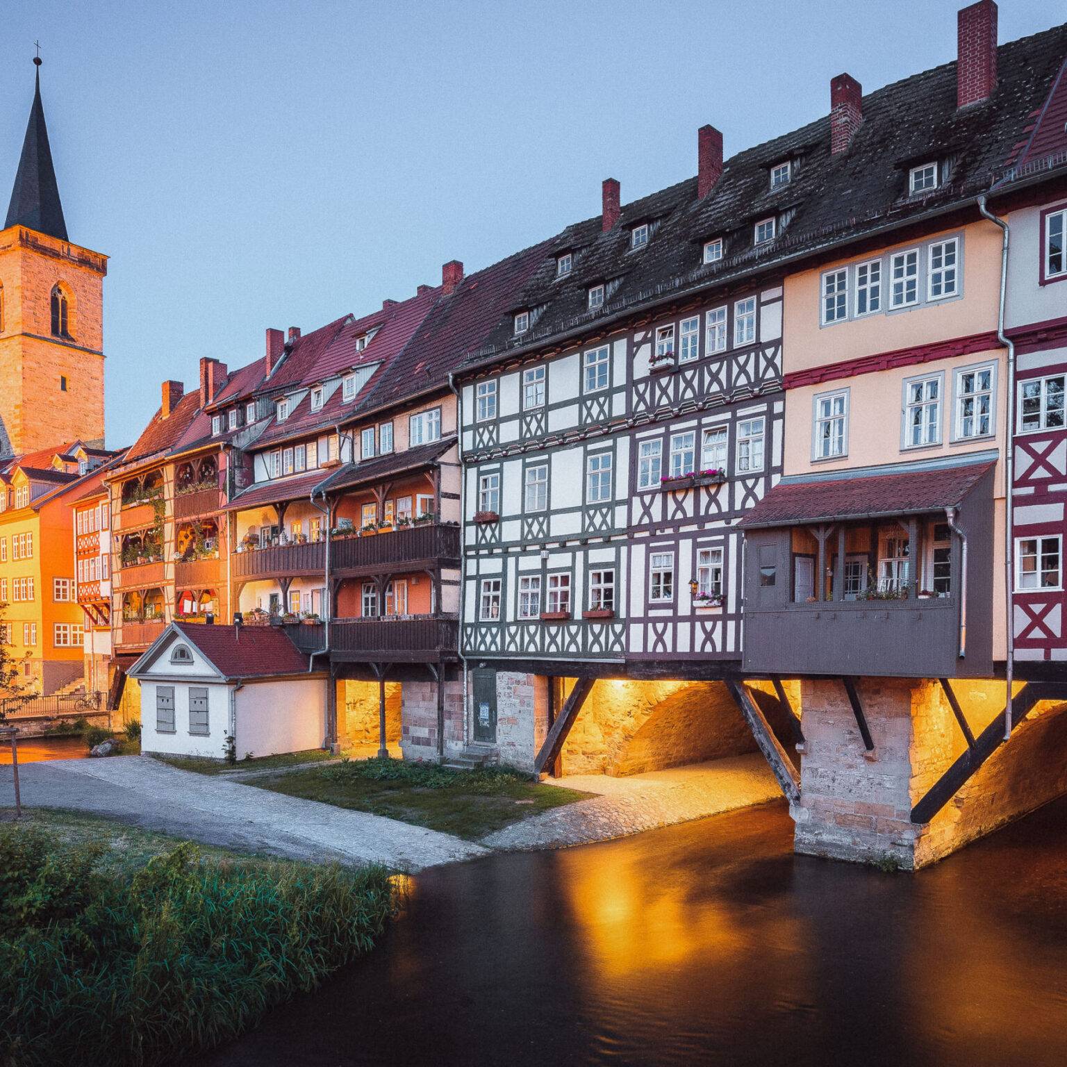 Die Krämerbrücke in Erfurt, eine niedrige steinerne Brücke, die dicht mit Fachwerkhäusern bebaut ist.
