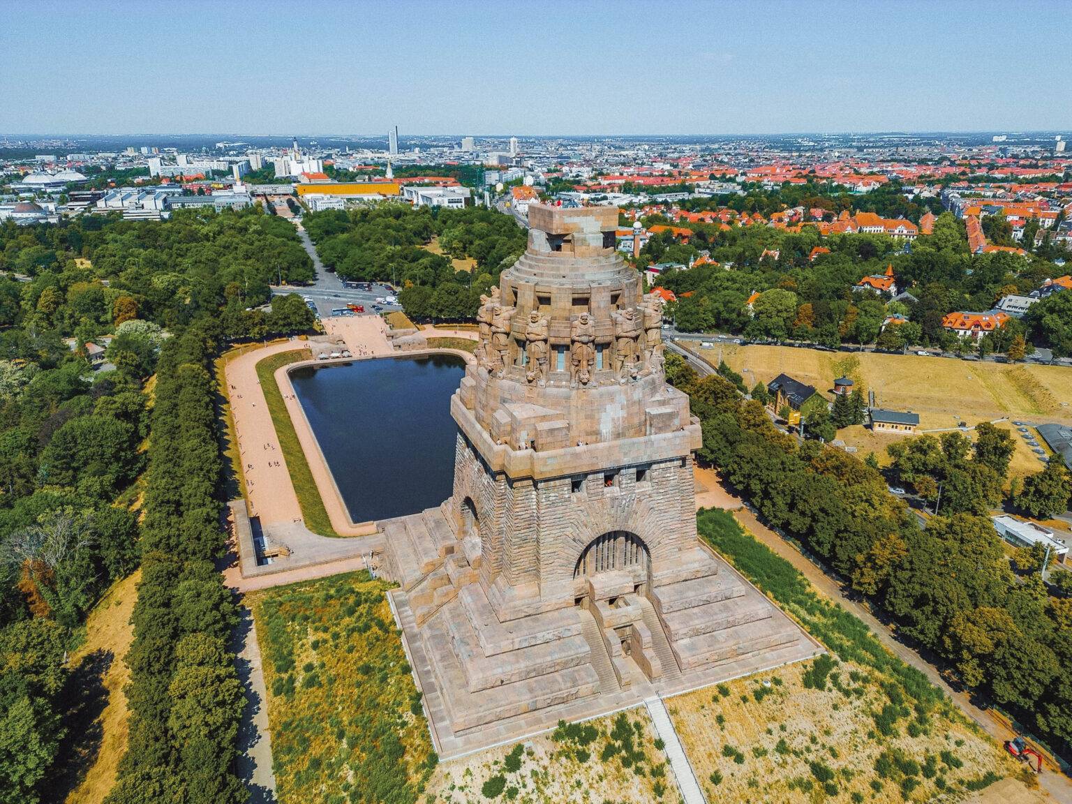 Das Völkerschlachtdenkmal in Leipzig aus der Vogelperspektive mit der Stadt im Hintergrund.