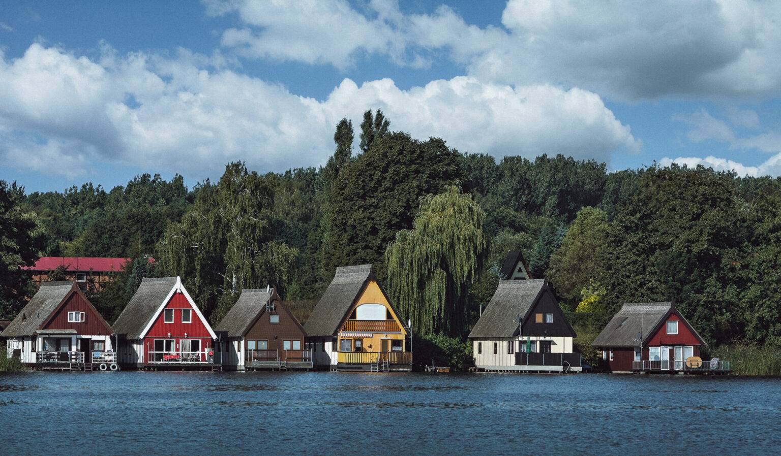 Einige kleine Häuschen direkt am Ufer eines Sees der Seenplatte Mecklenburg-Vorpommern.