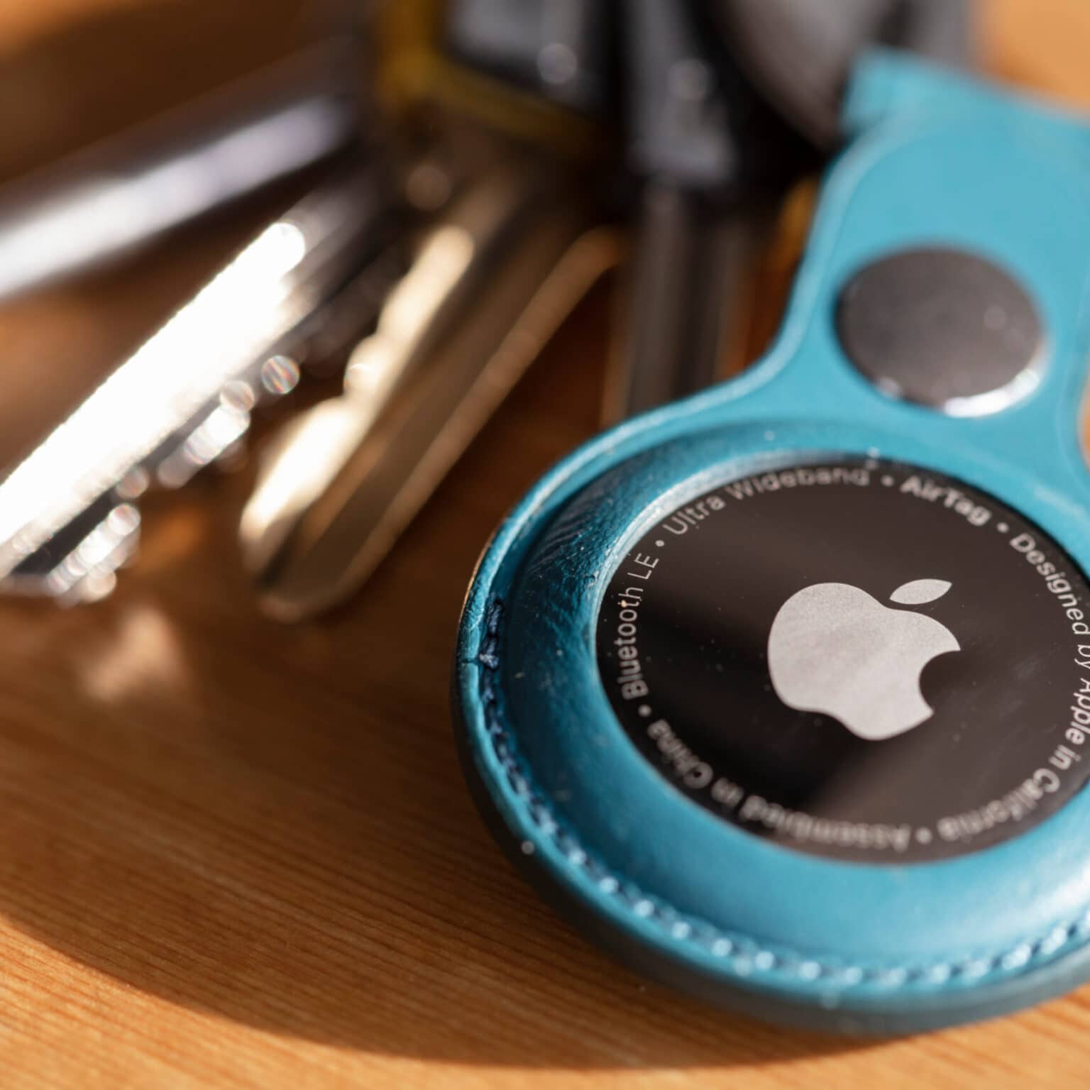 Ein Apple Air Tag an einem blauen Schlüsselanhänger.