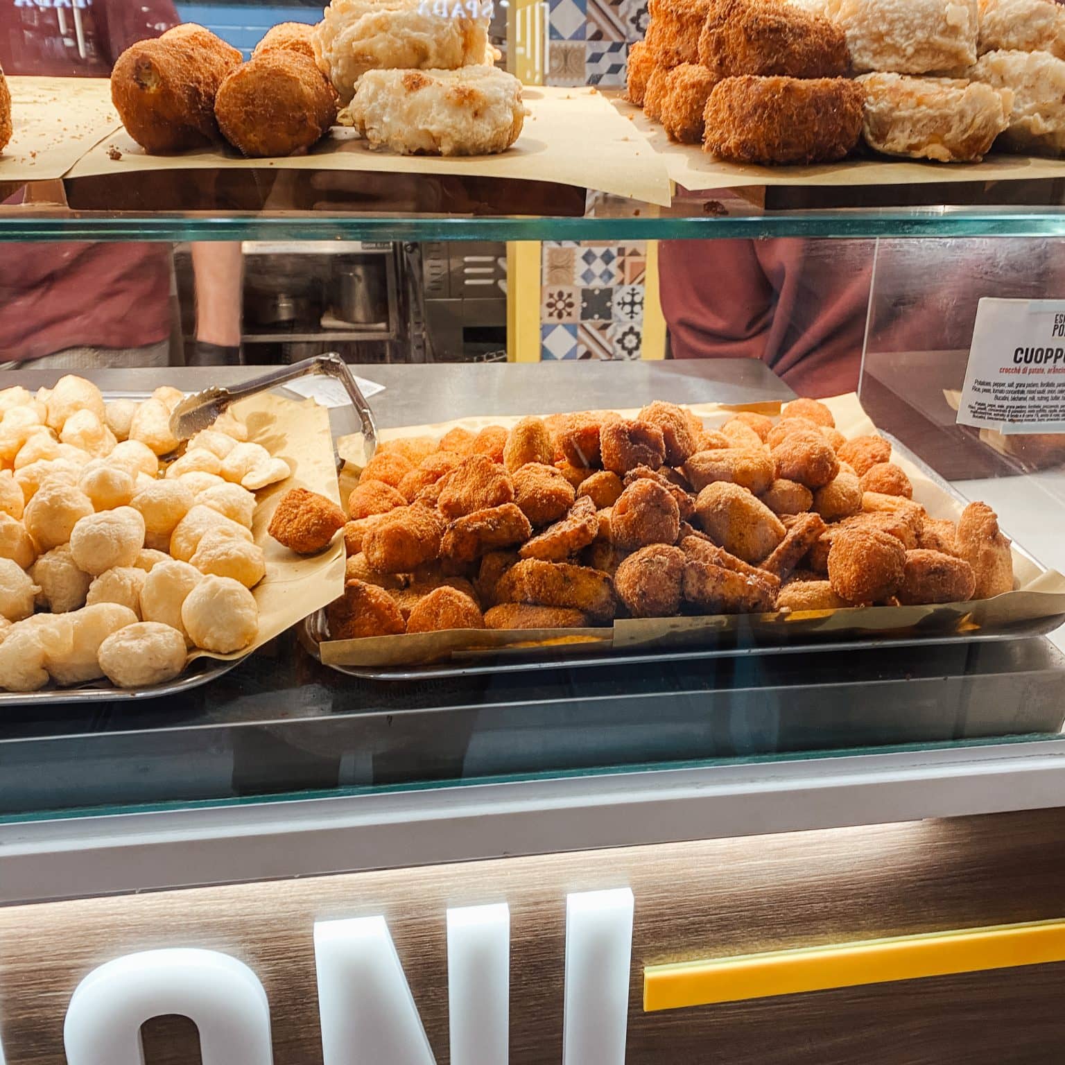 Eine Auslage eines Marktstandes mit vielen unterschiedlichen frittierten Snacks.