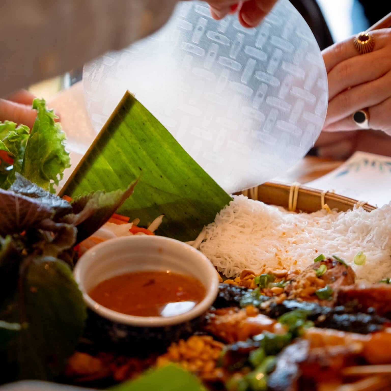 Ein vietnamesisches Gericht mit Reisnudeln, Fleischspießen und Salat.