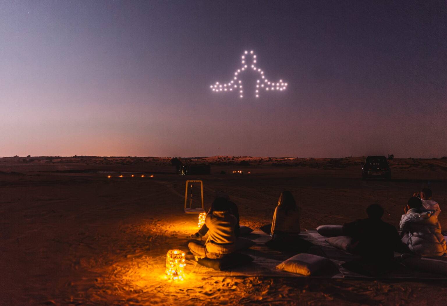 Die Drohnen erzählen eine Geschichte am nächtlichen Wüstenhimmel.