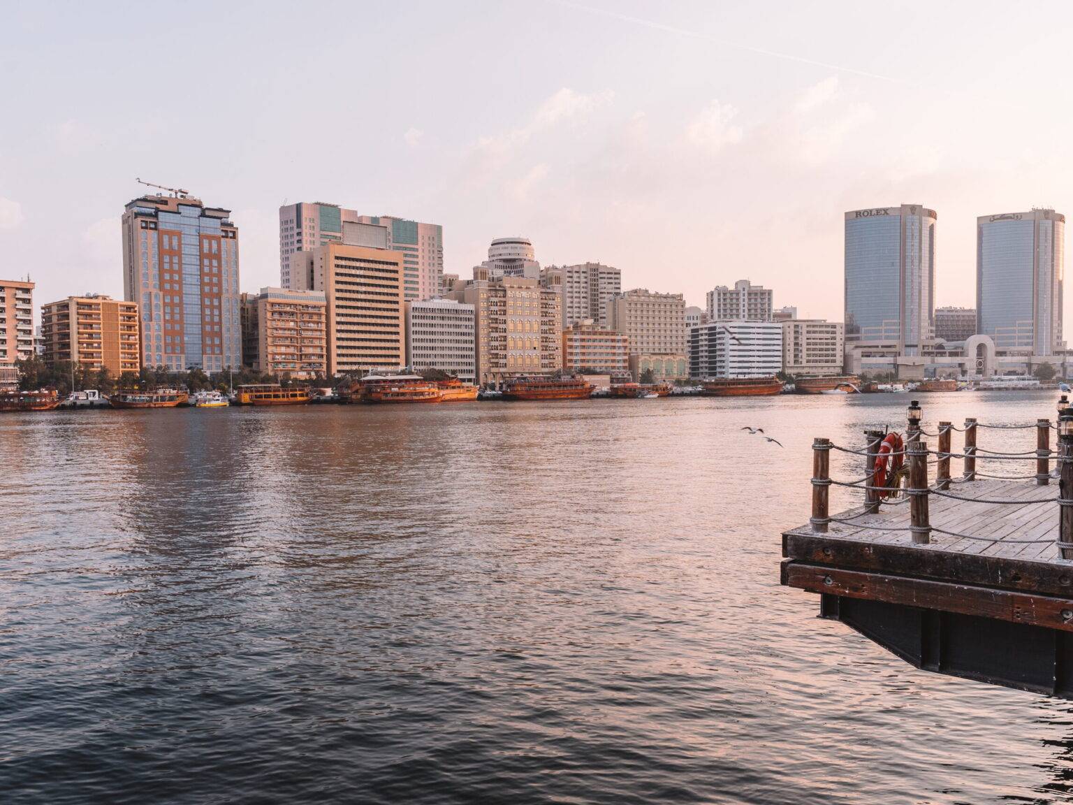 Der Dubai Creek in der Morgendämmerung mit den Gebäuden der Altstadt im Hintergrund.