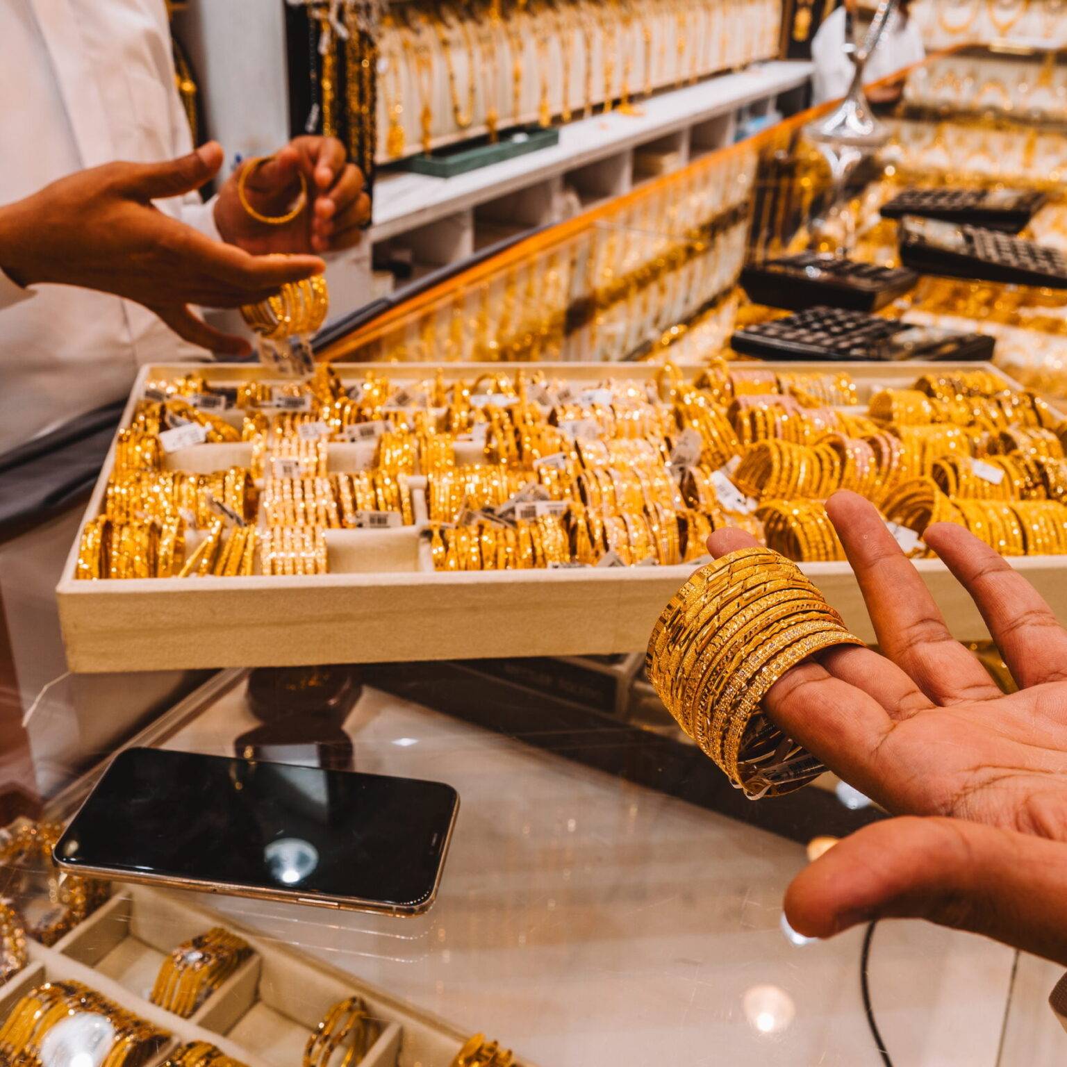 Schmuckstücke aus Gold in der Hand der Händler im Gold Souk.