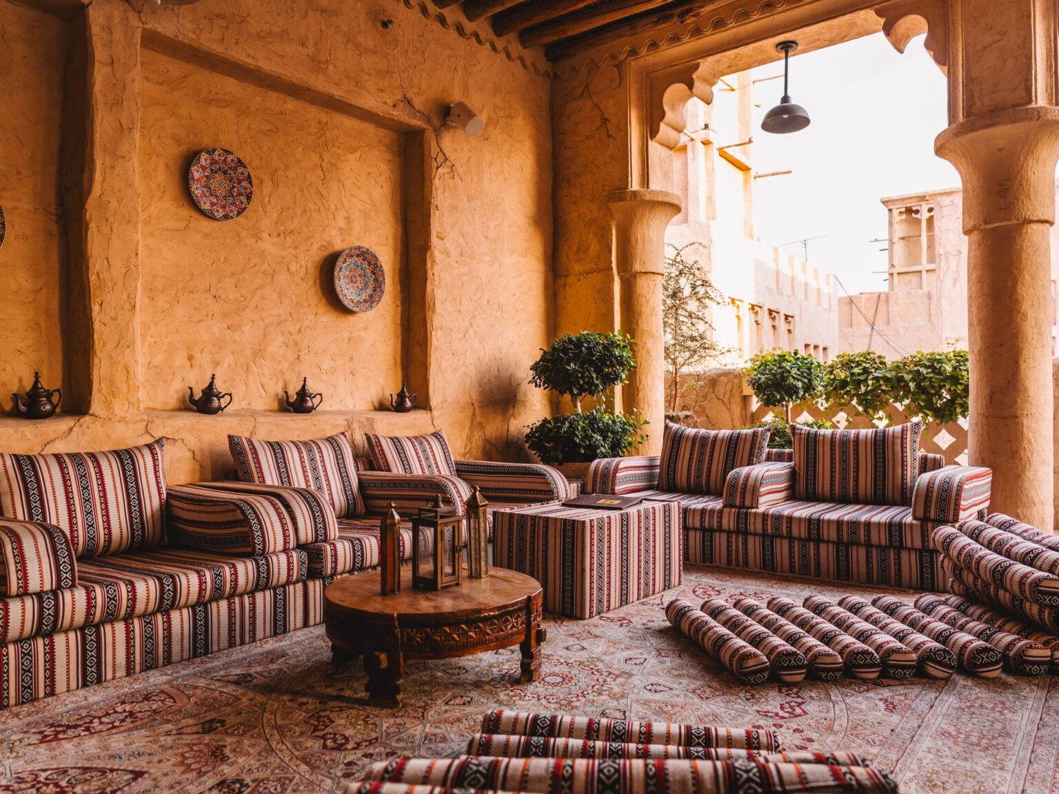 Eine halboffene Sitzecke mit bunt gemusterten Polstern im Al Seef Heritage Hotel.