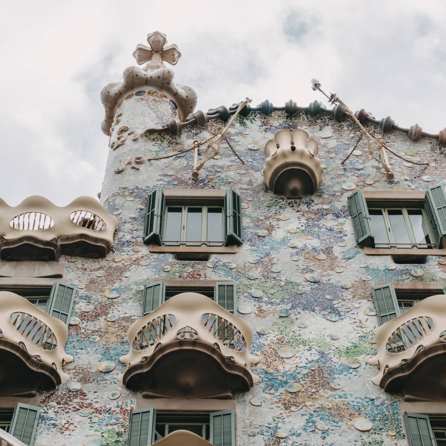 Die Fassade der Casa Battlo mit blauen, grünen und orangefarbenen Mosaiken.