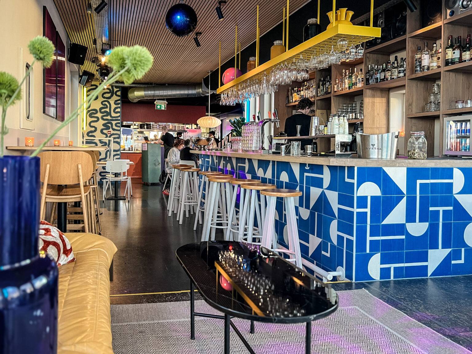 Die Innenraum im Restaurant REM mit blauer Theke und verschiedenen Sitzmöglichkeiten.