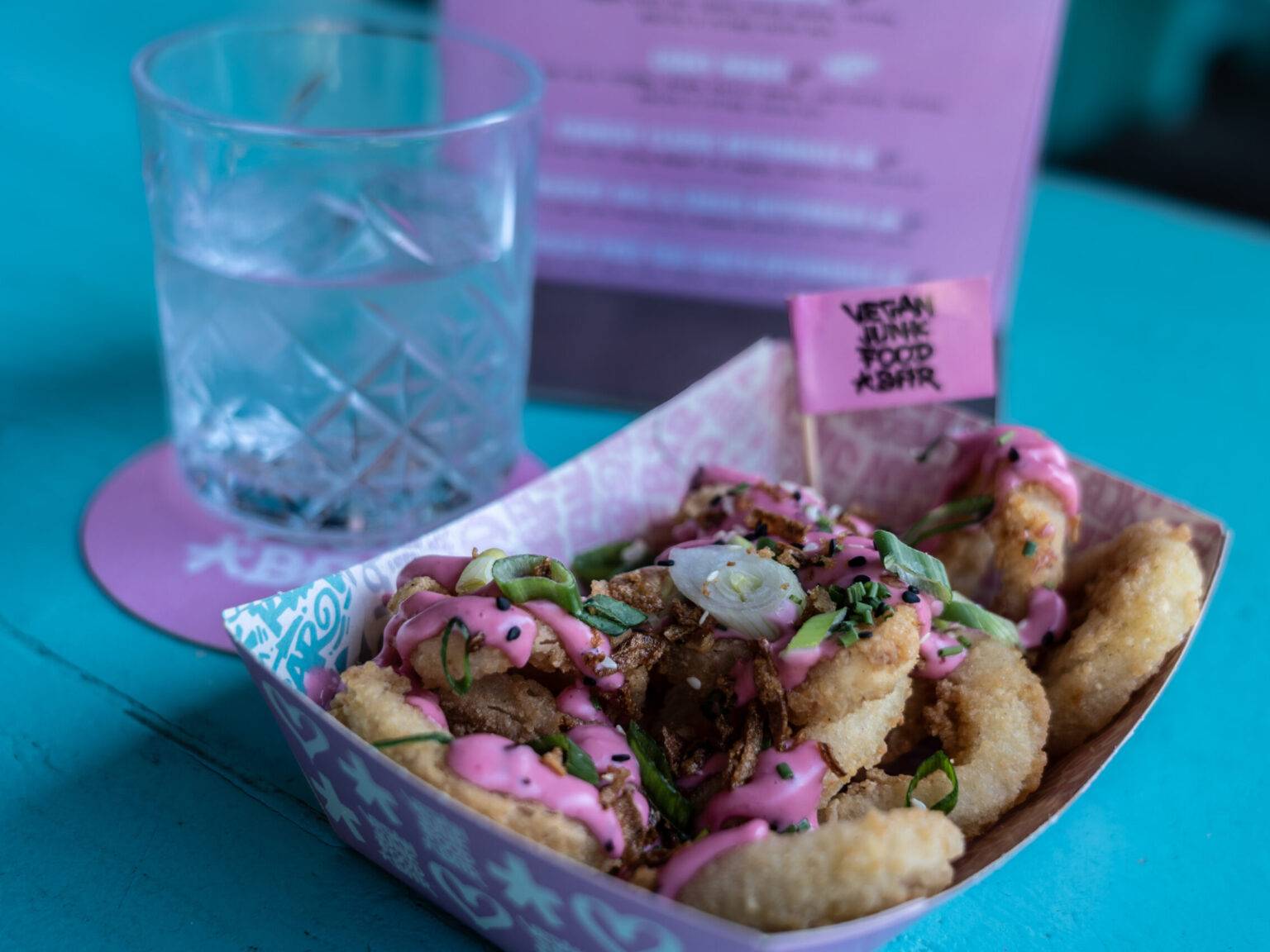 Vegane Kalamari mit knuspriger Panade und leuchtend pinker Soße, serviert in der Vegan Junk Food Bar in Amsterdam.