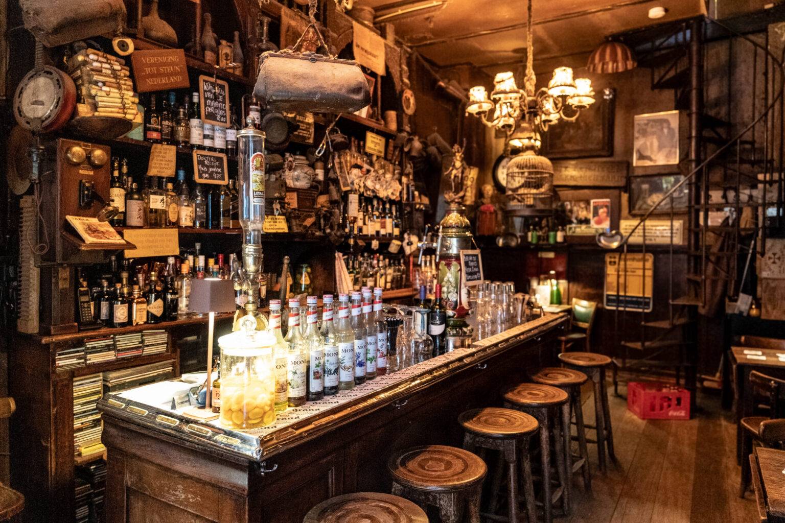 Innenansicht des winzigen Bruin Cafés Het Doktertje in Amsterdam mit dunkler Holzvertäfelung, antikem Interieur und gemütlicher Atmosphäre.