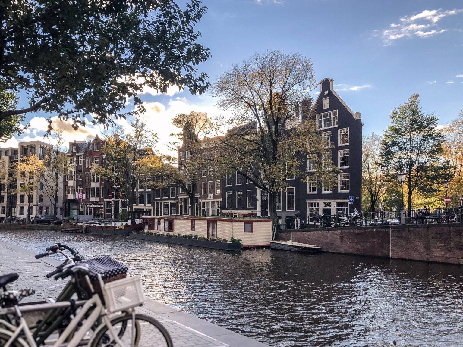 Typische Gracht im Amsterdamer Viertel Jordaan mit Backsteinhäusern, Hausbooten und kleinen Shops.