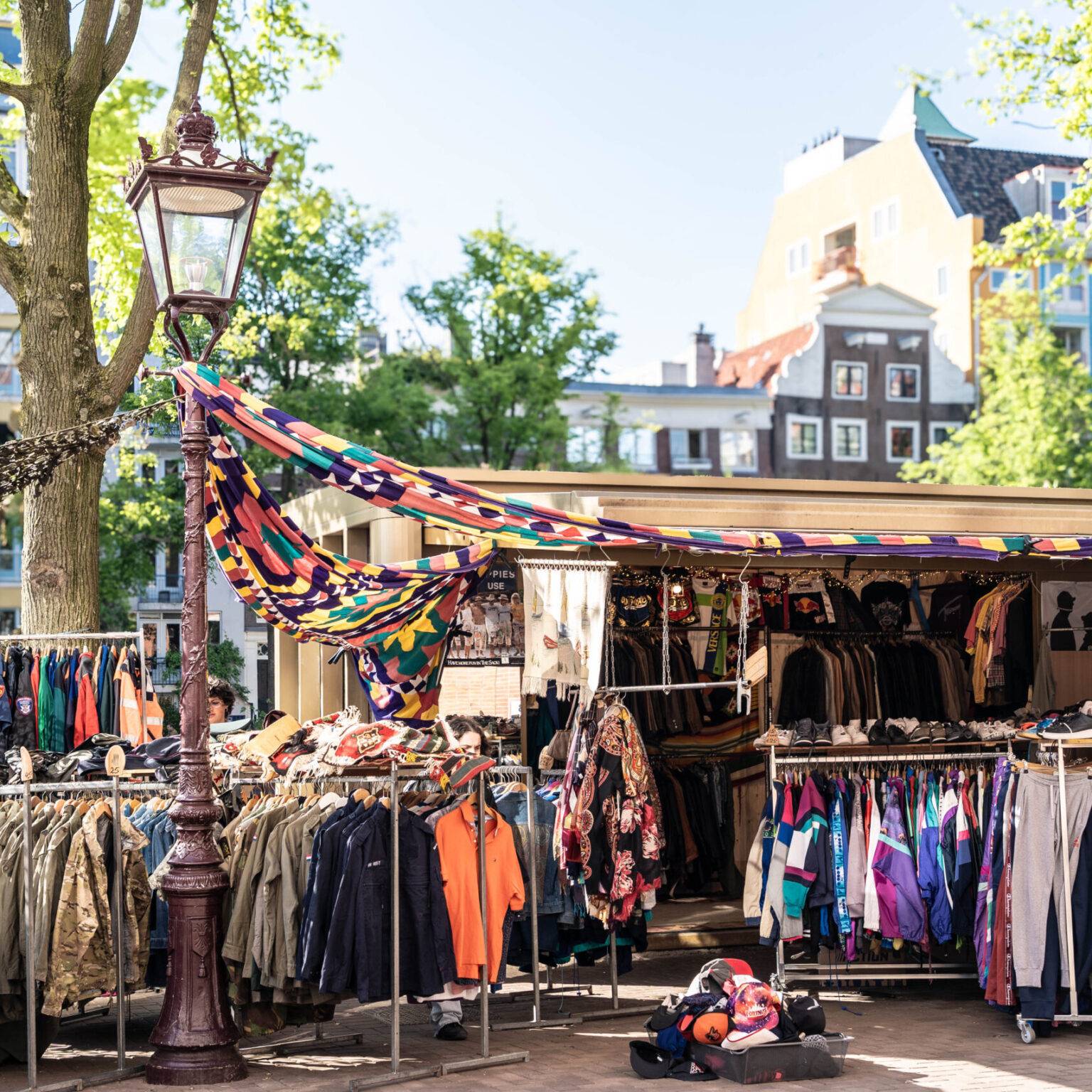 Marktstand mit Kleidung und Accessoires auf dem belebten Waterlooplein Flohmarkt in Amsterdam.