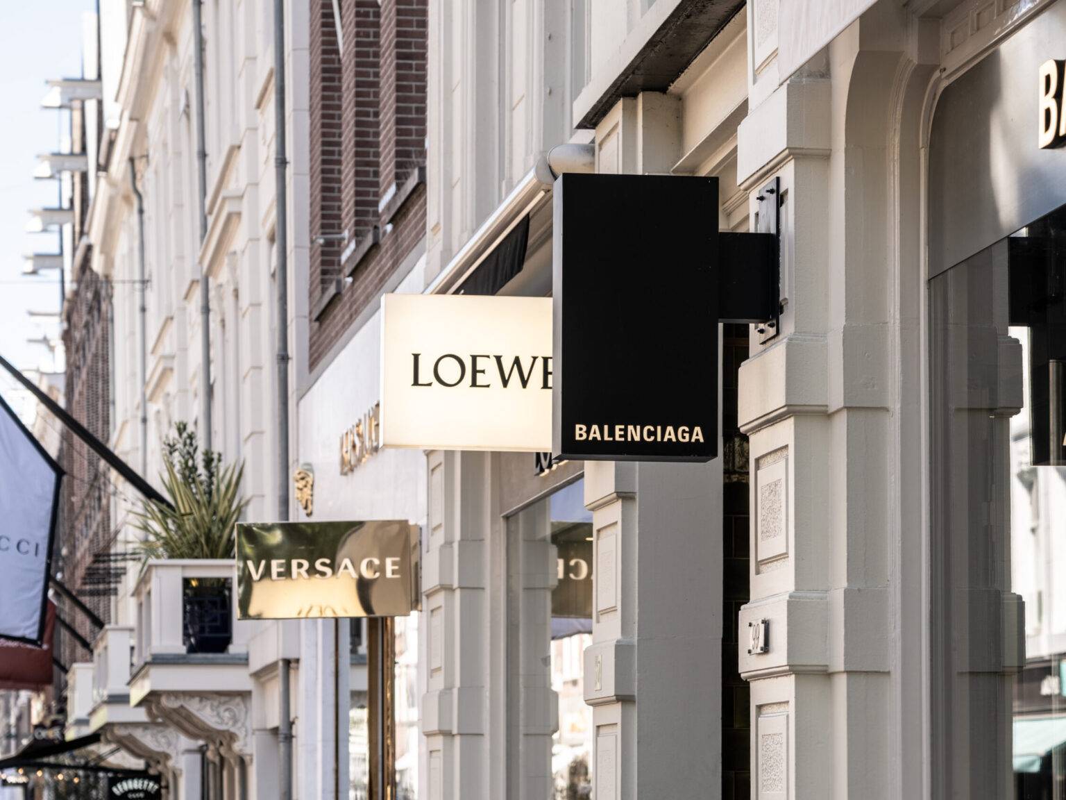 Schilder mehrerer Luxusmarken an der P.C. Hooftstraat in Amsterdam, bekannt als die High-End-Shoppingstraße der Stadt.