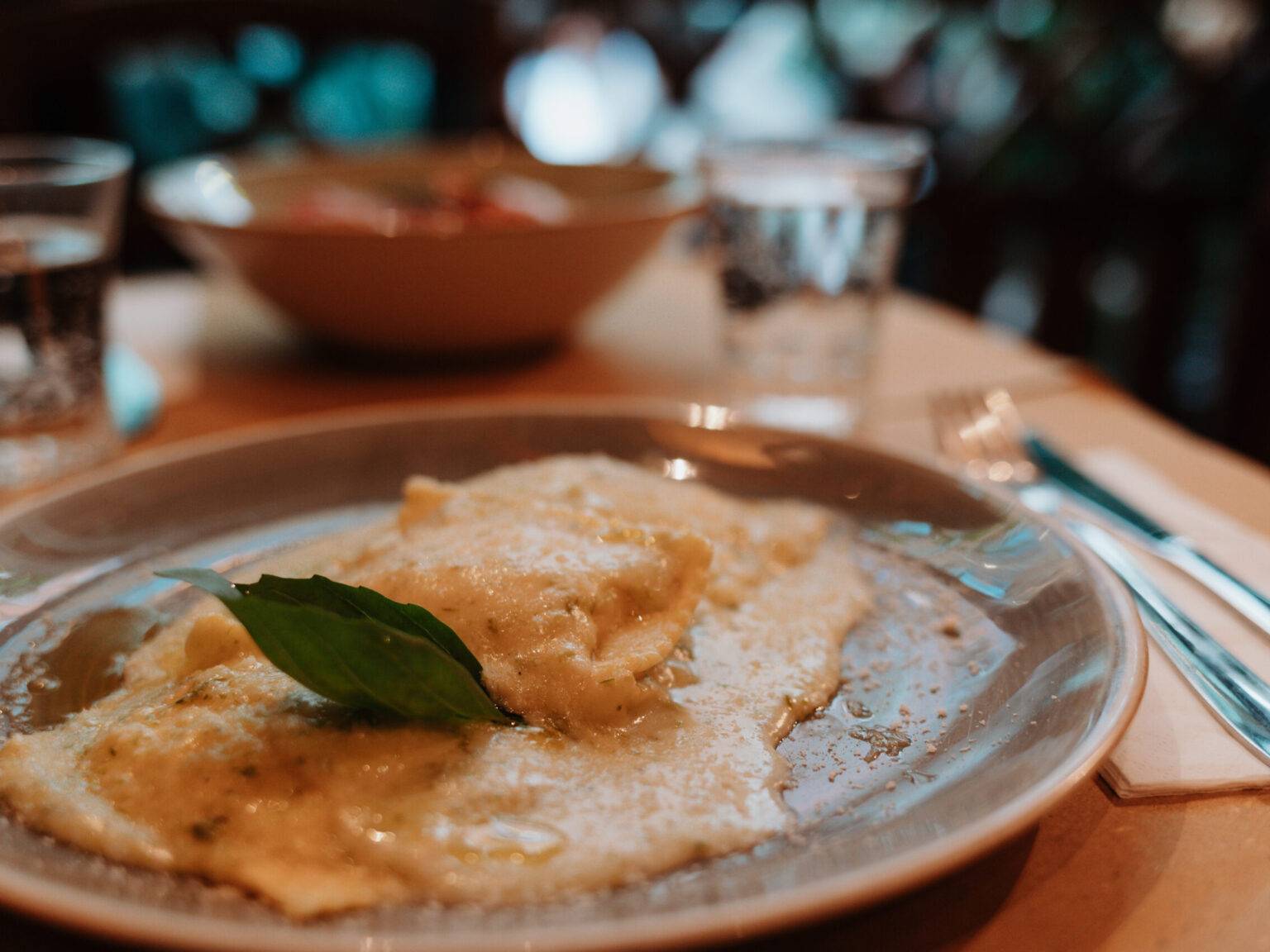 Hausgemachte Ravioli mit cremiger Sauce und Basilikum.