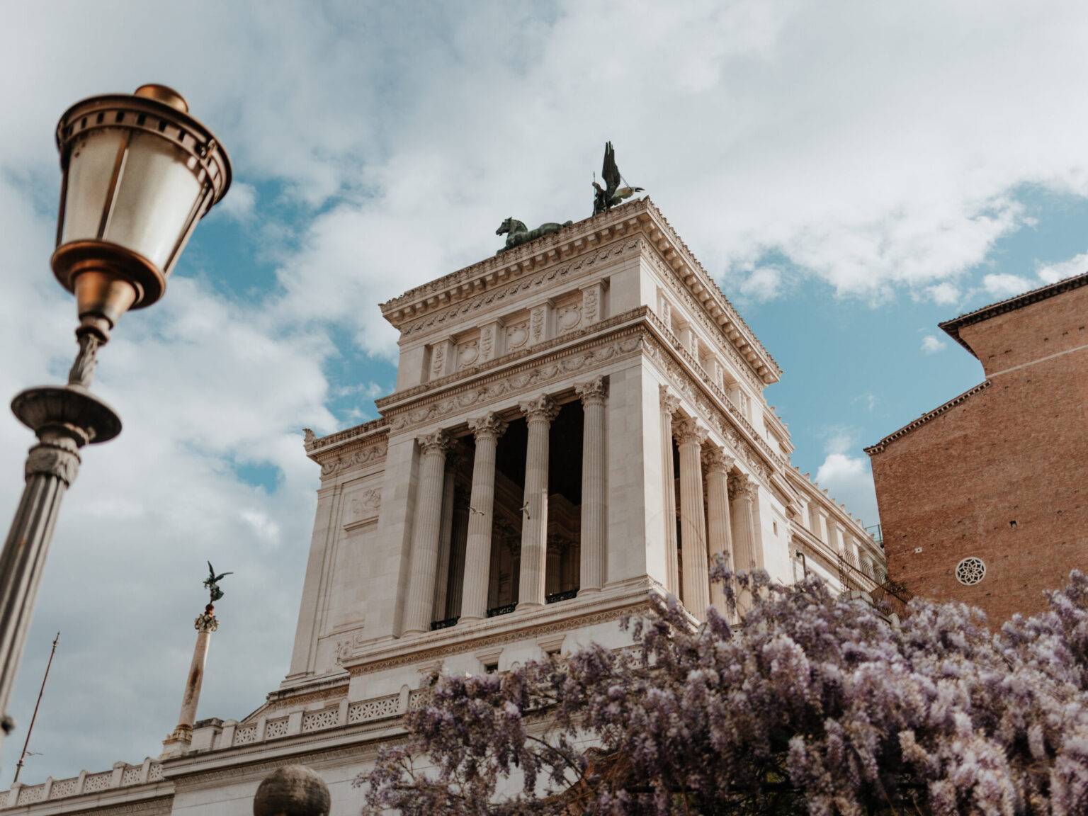 Monumento Vittorio Emanuele II in Rom mit Säulen, Reiterstatue und blühendem Blauregen.
