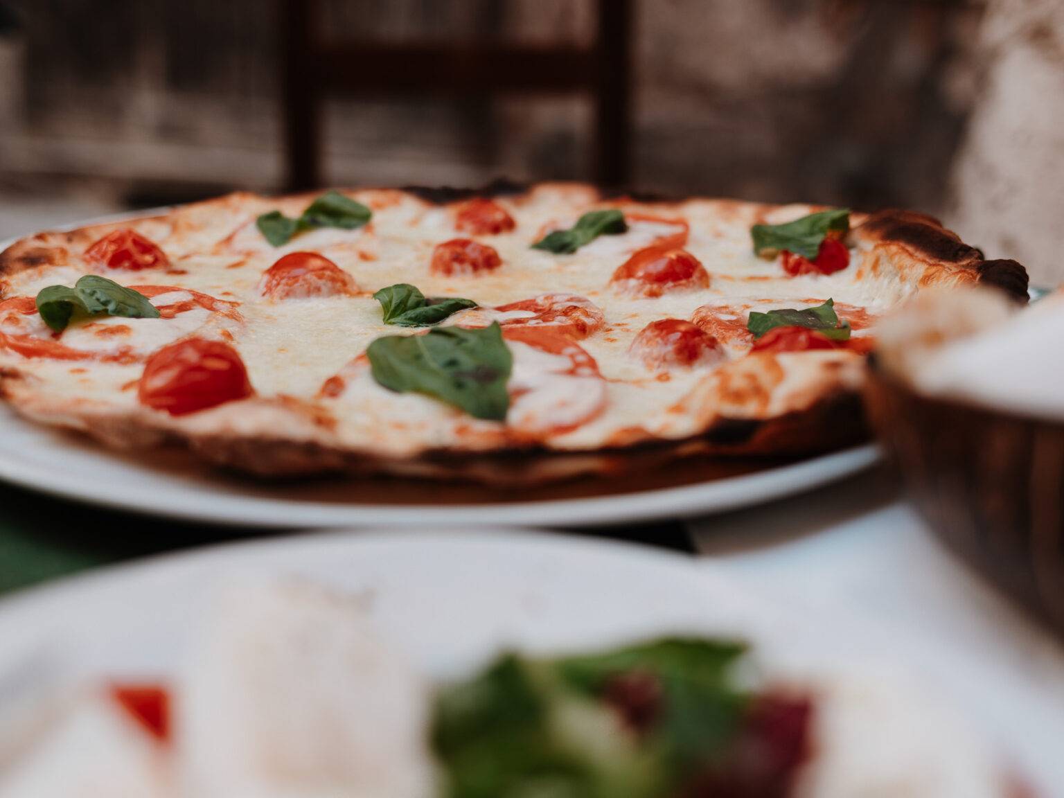 Knusprige Pizza Margherita mit Tomaten und Basilikum, serviert bei Lo Zozzone in Rom.