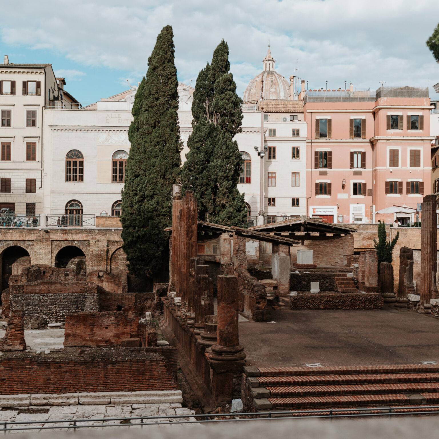 Antike Tempelruinen am Largo di Torre Argentina mit sonnenbadenden Katzen zwischen den Steinen.