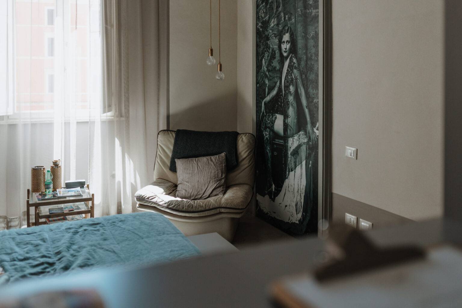 Gemütliches Zimmer im CasaCau nahe Trevi-Brunnen mit Sessel, Kunstfoto und Lichtspiel.