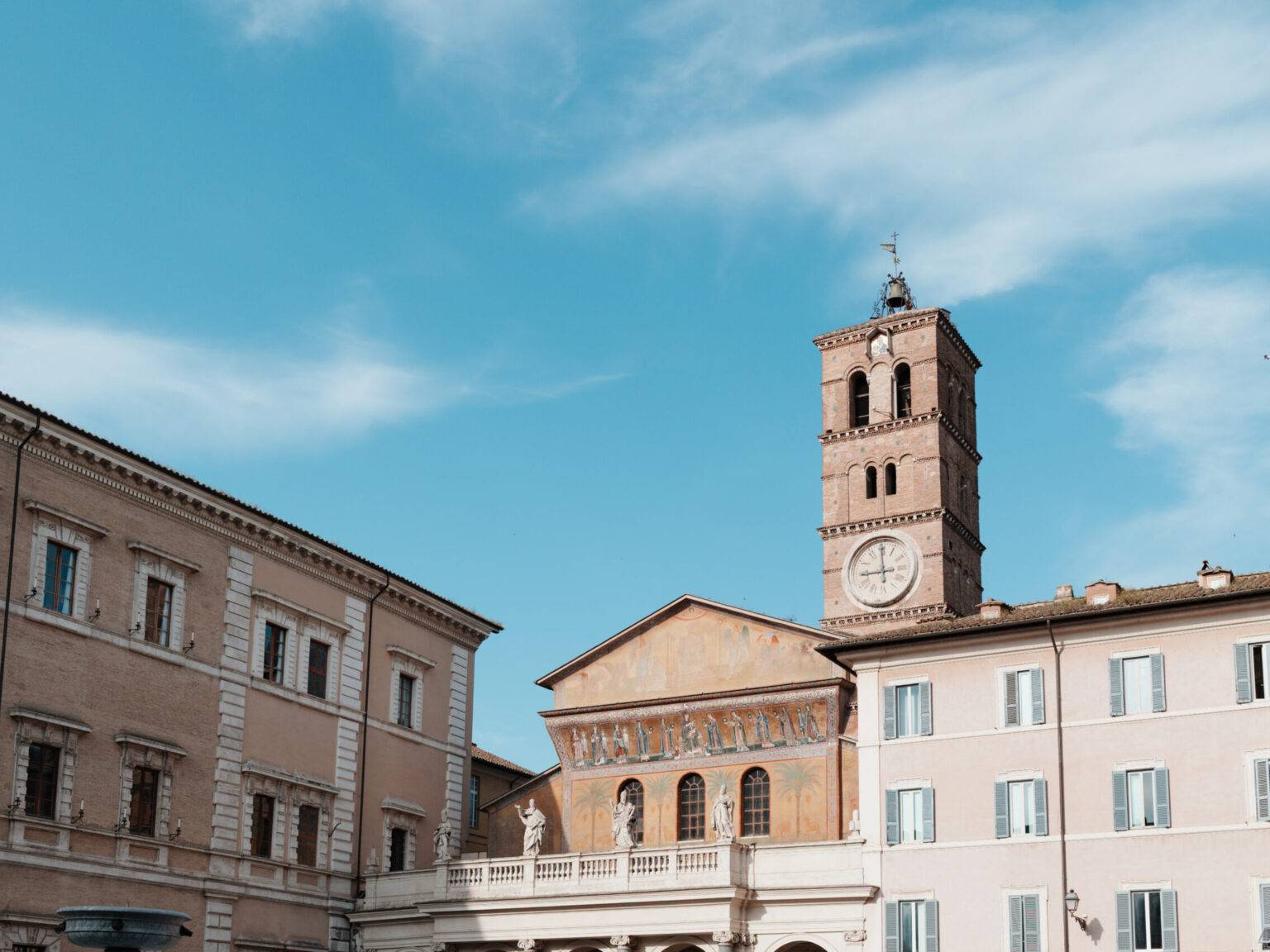 Piazza Santa Maria in Trastevere mit der gleichnamigen Basilika bei Tageslicht.