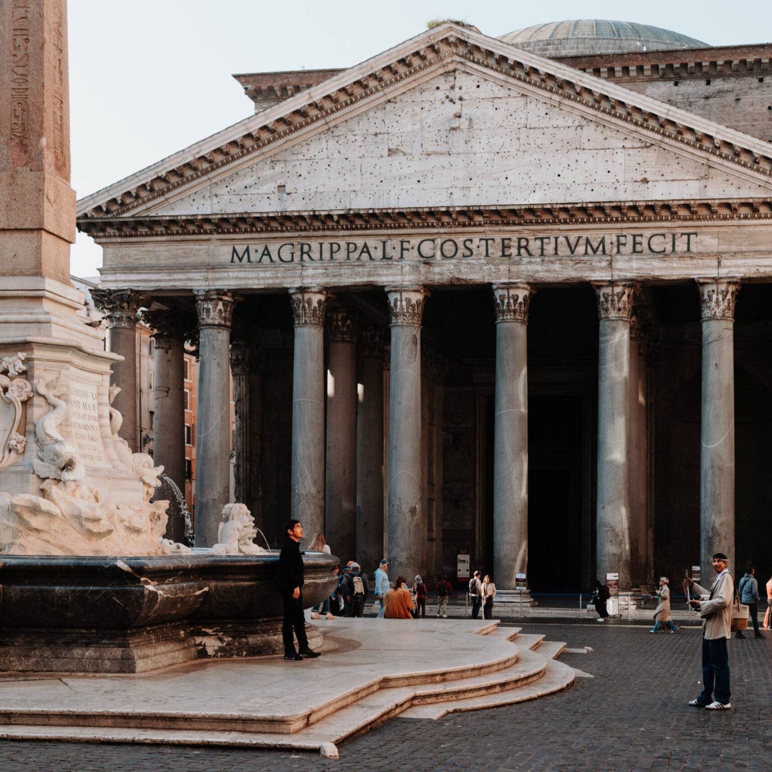 Pantheon in Rom mit Brunnen und Obelisk auf dem Platz davor, umgeben von Besuchern.