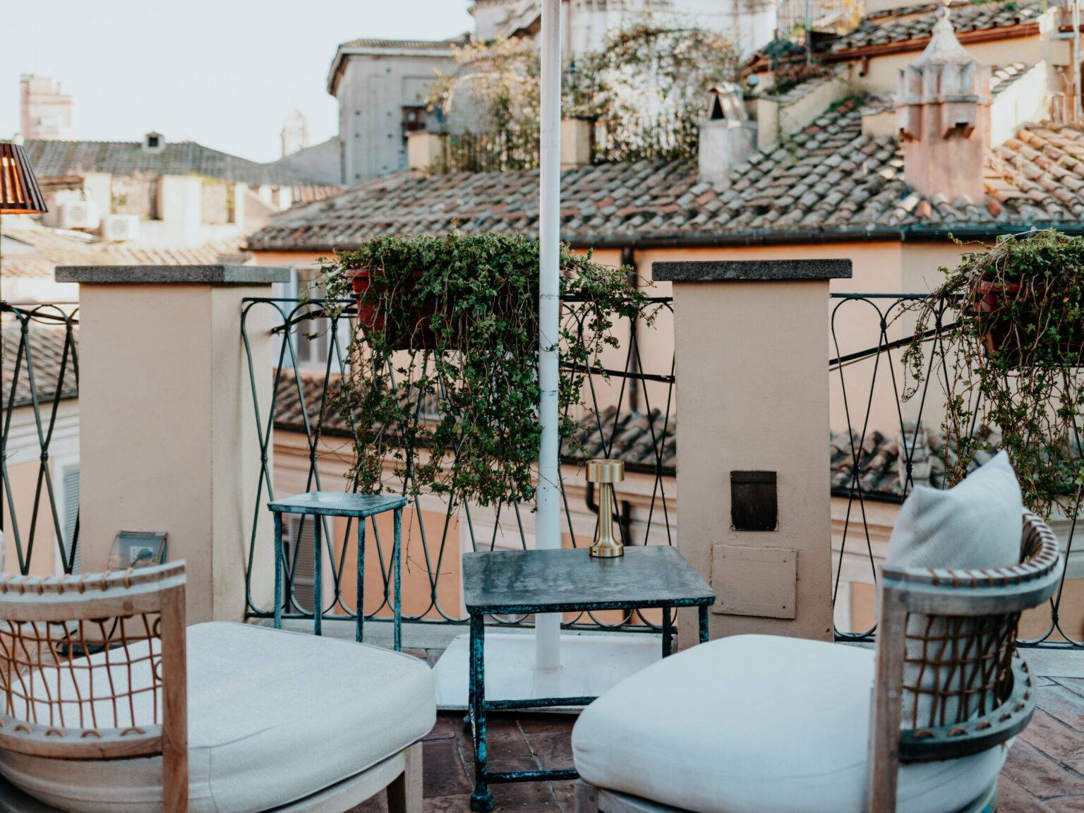 Gemütliche Dachterrasse des Hotels Cesàri in Rom mit Blick auf Ziegeldächer und Sitzgelegenheiten.