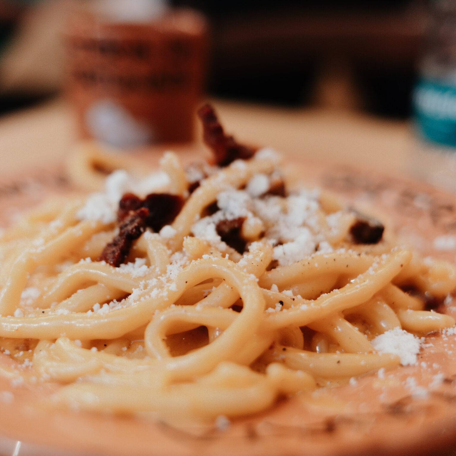 Portion Pasta alla Carbonara auf einem Teller mit Osteria da Fortunata-Schriftzug.