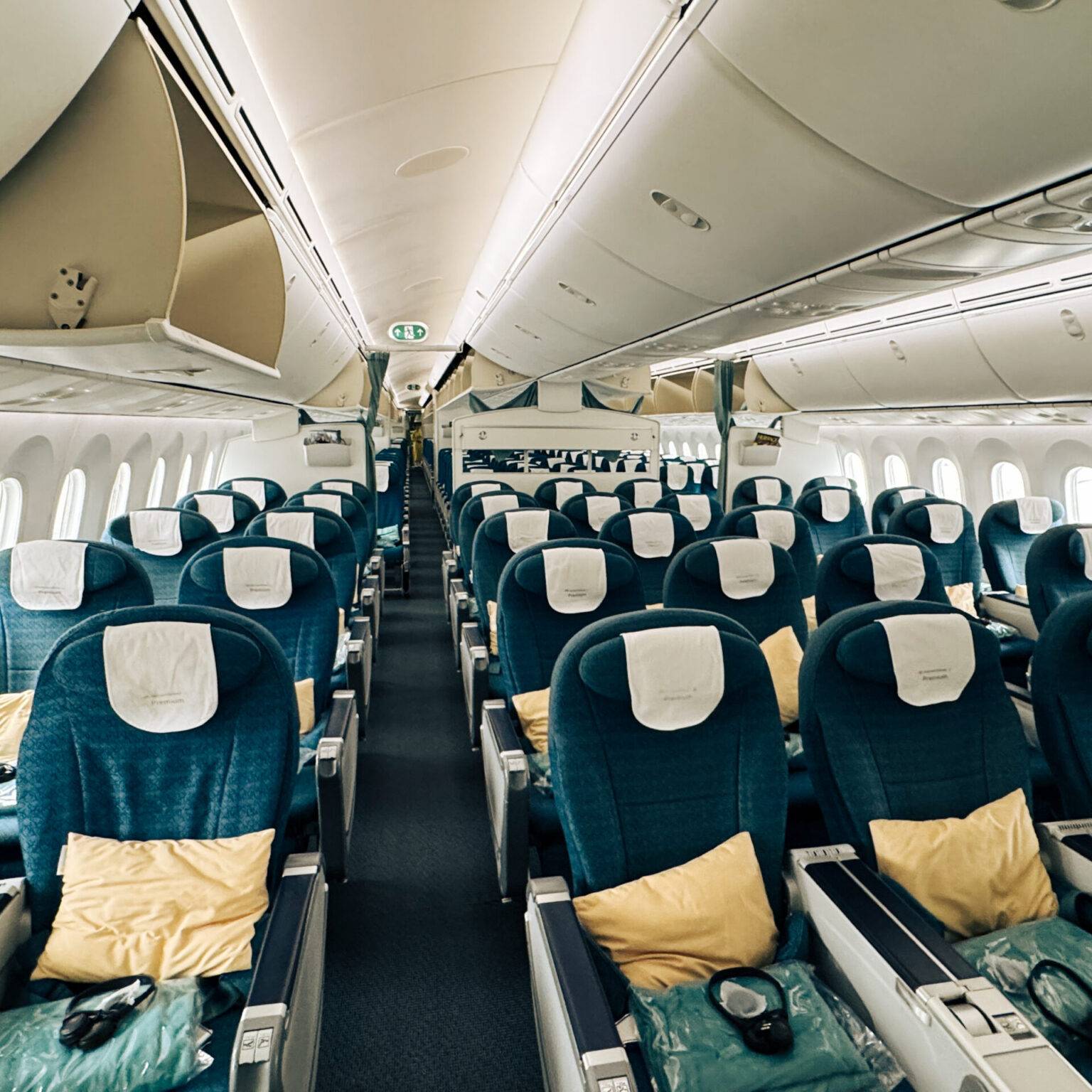 Die Kabine der Vietnam Airlines Economy Class mit blauen sitzen und zusätzlichen Decken und Kissen.