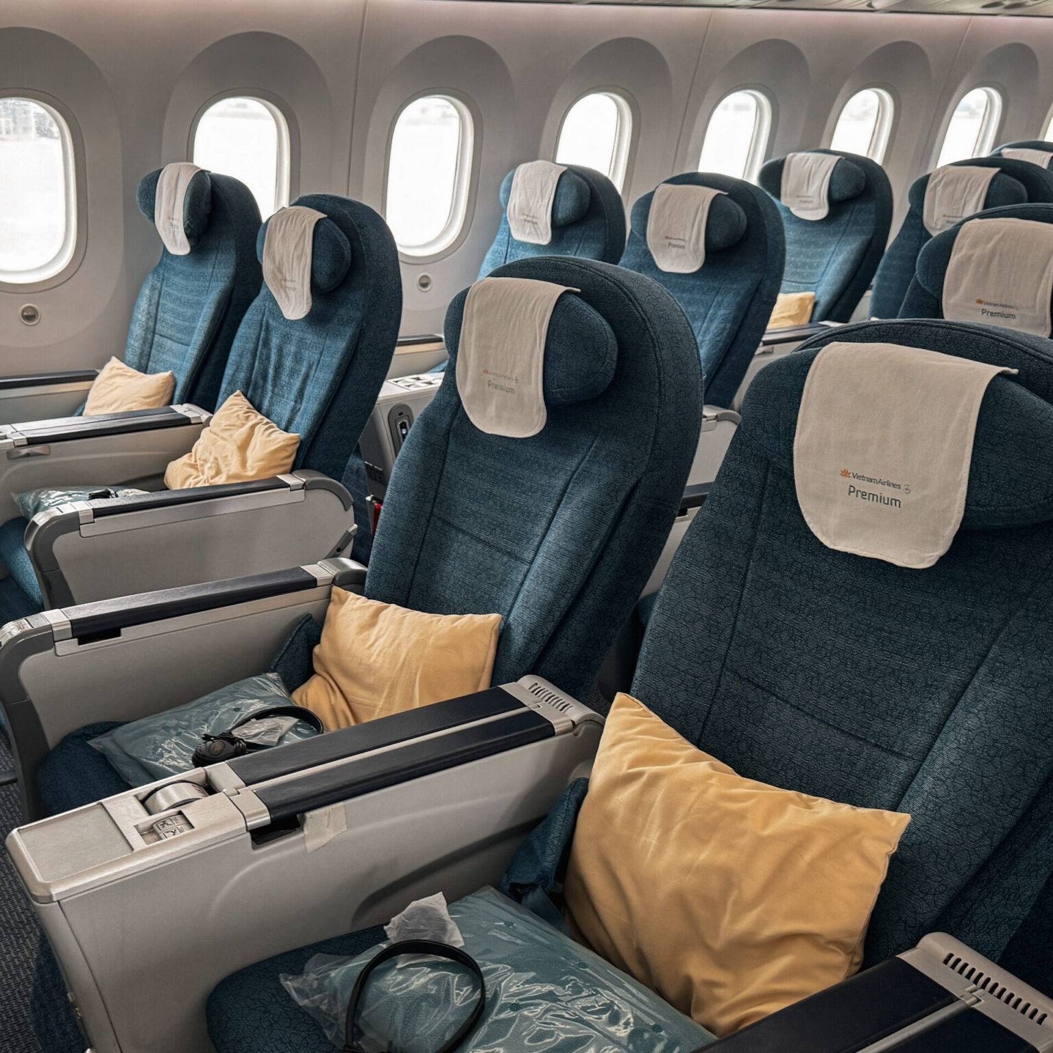 Die Kabine der Vietnam Airlines Premium Economy Class mit blauen sitzen und zusätzlichen Decken und Kissen.