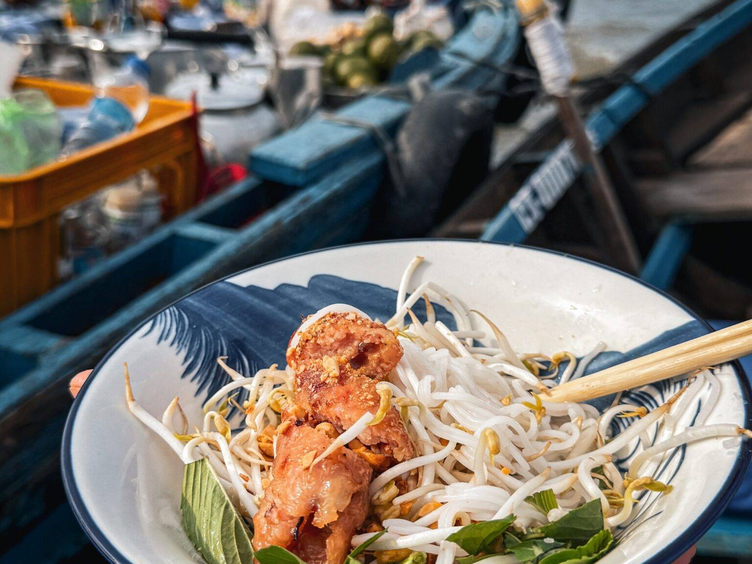 Eine Schale mit Essen. Im Hintergrund sind Boote auf dem Wasser.