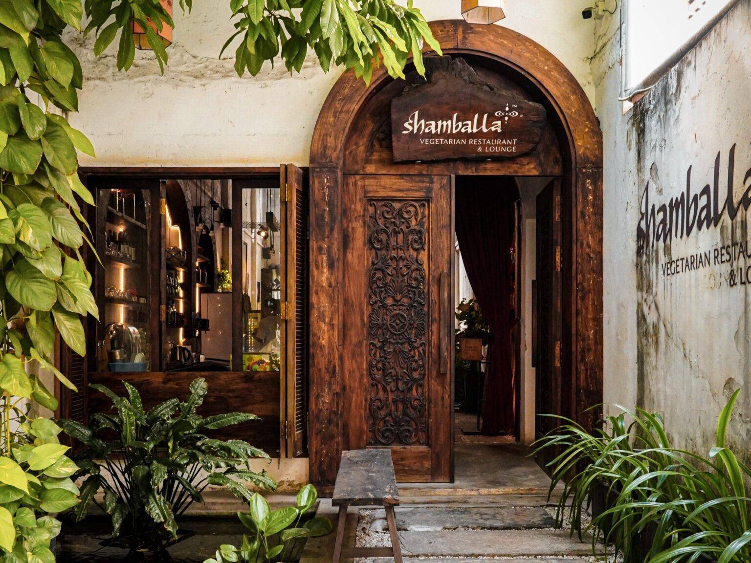 Die große hölzerne Eingangstür des Shamballa Restaurant.