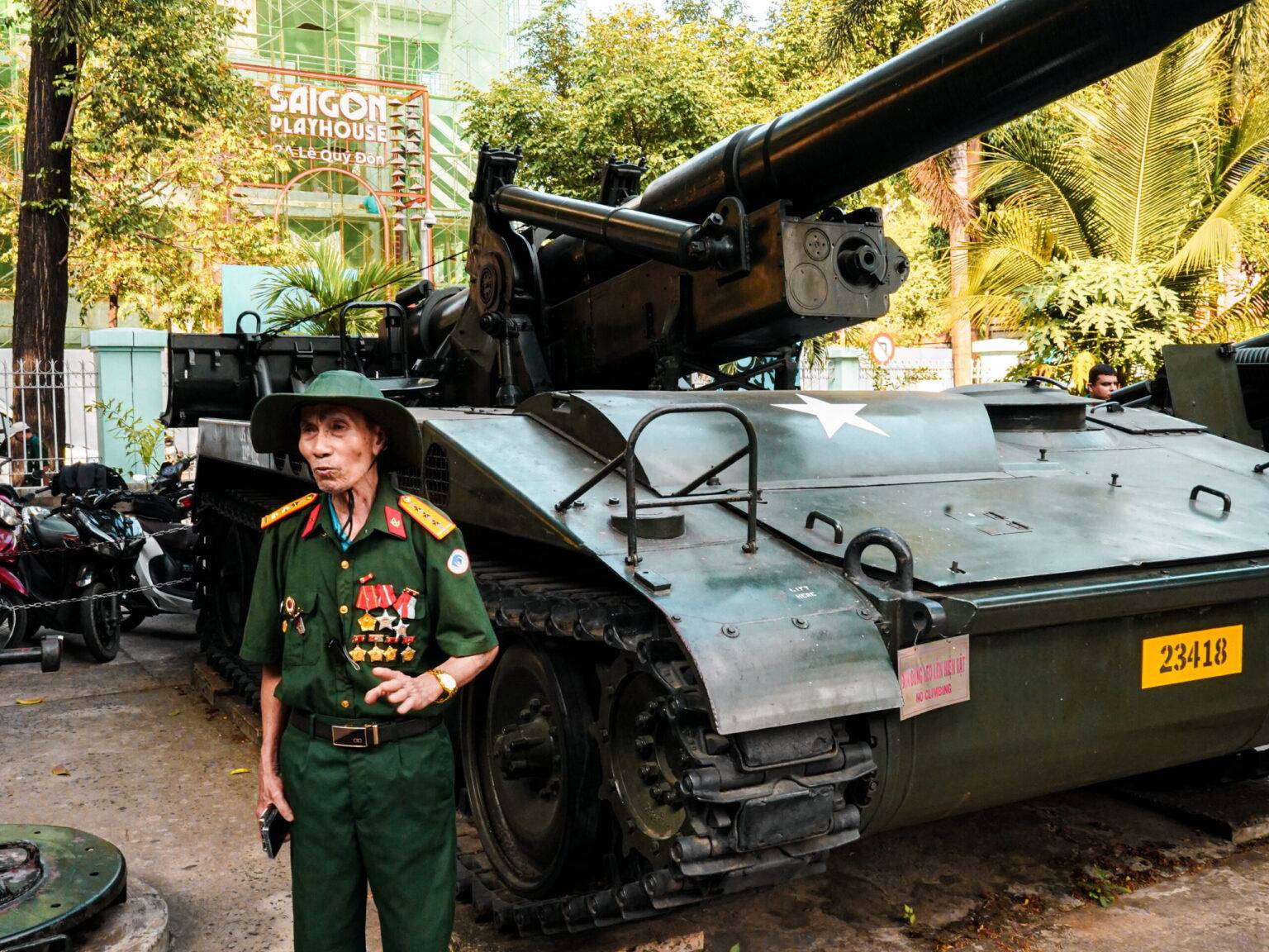 Ein Veteran in Uniform steht vor einem altern Panzer im War Museum in Saigon.