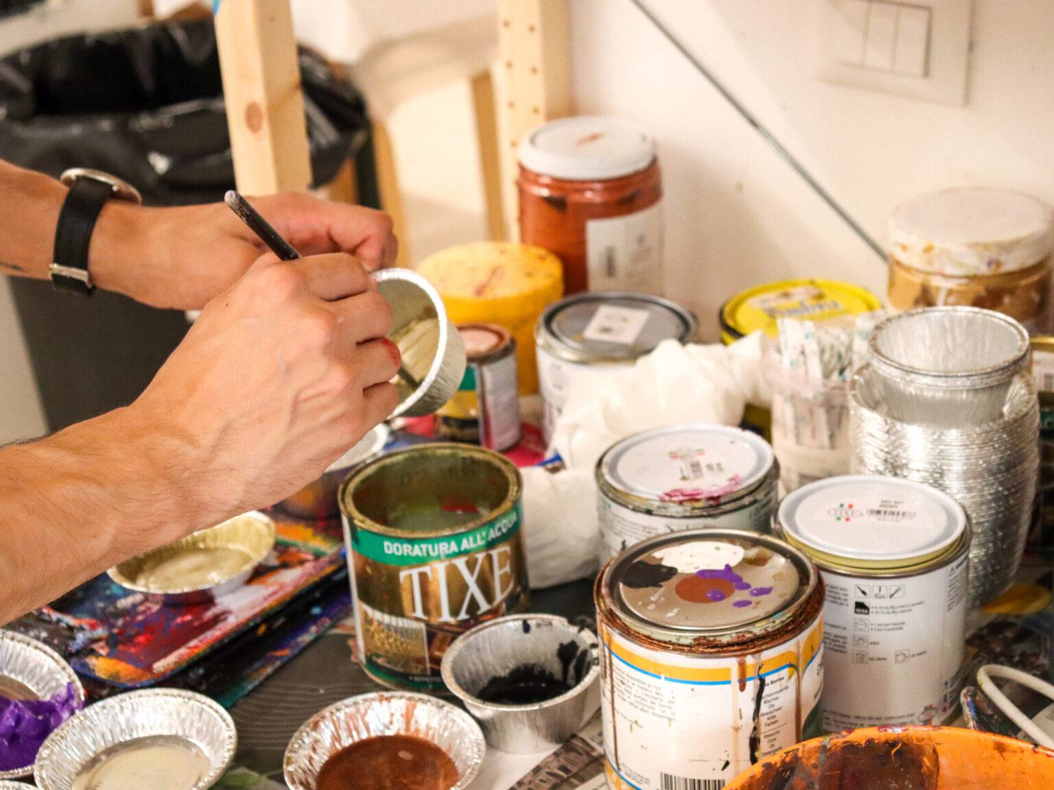 Farben werden angerührt, um damit Masken zu bemalen.