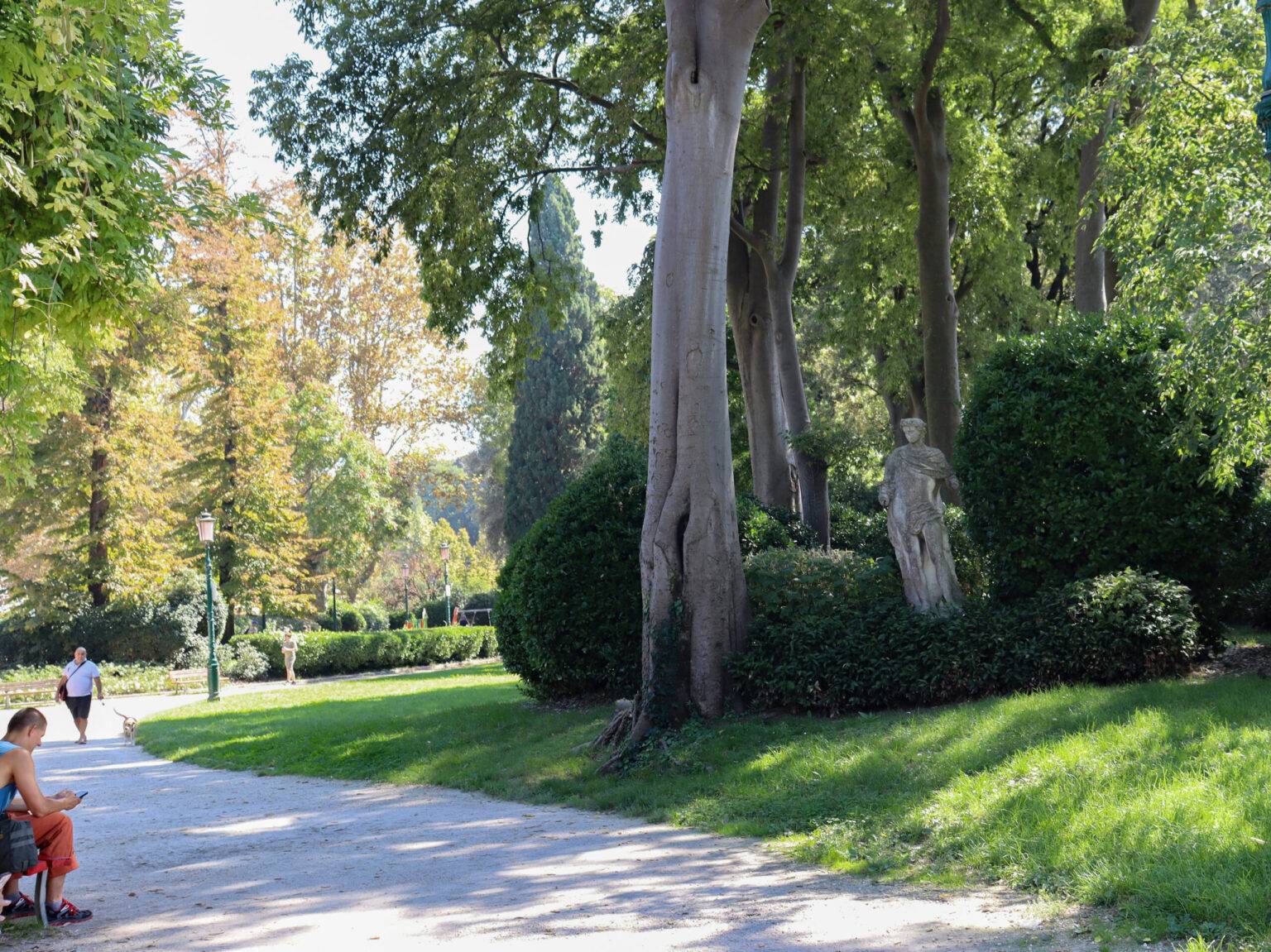 Der Giardini della Biennale: Ein grüner Park mit Kiesweg und Statue.