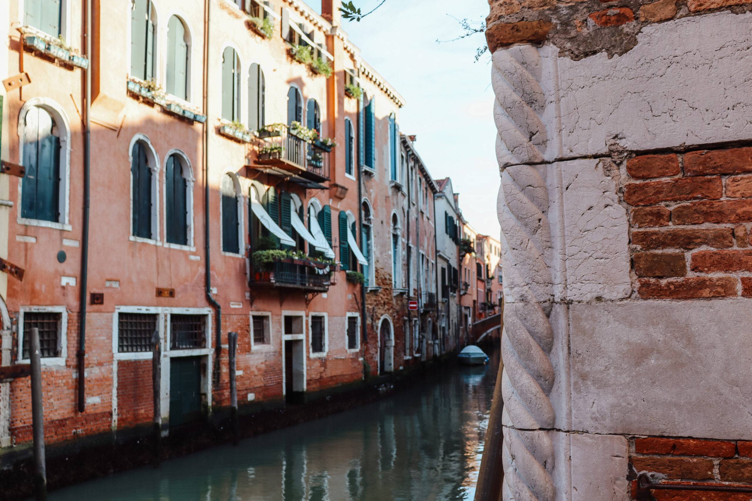Ein Seitenkanal in Cannaregio mit rosanen Häuserfassaden links.