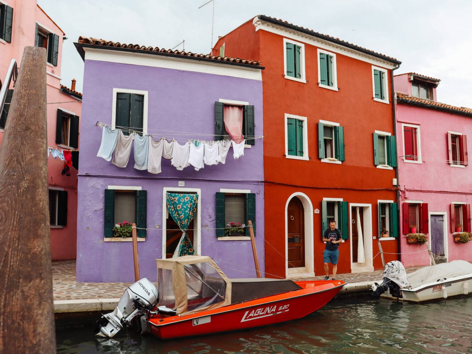 Bunte Häuserfassaden und Boote am Kanal auf Burano.