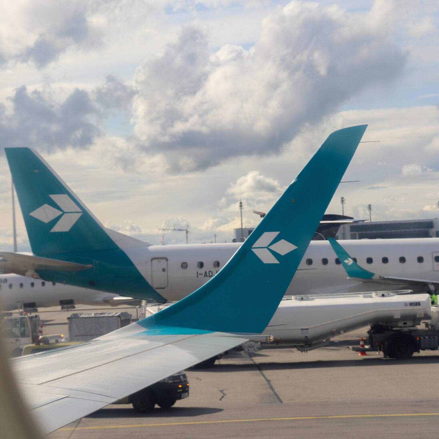 Mehrere Flugzeuge von Air Dolomiti parken nebeneinander auf dem Rollfeld.