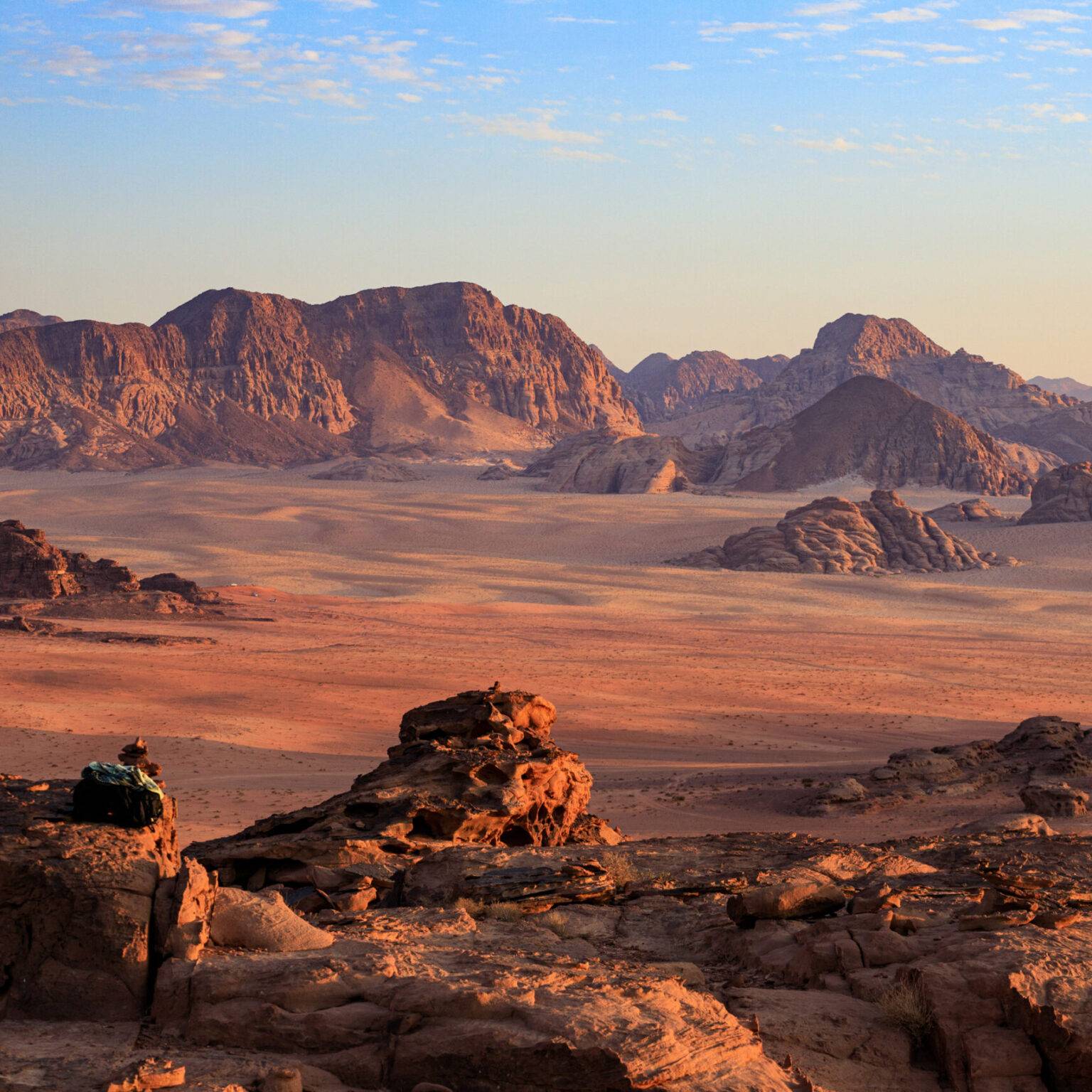 Die Felswände in Jordaniens Wüste Wadi Rum leuchten rot im Abendlicht.