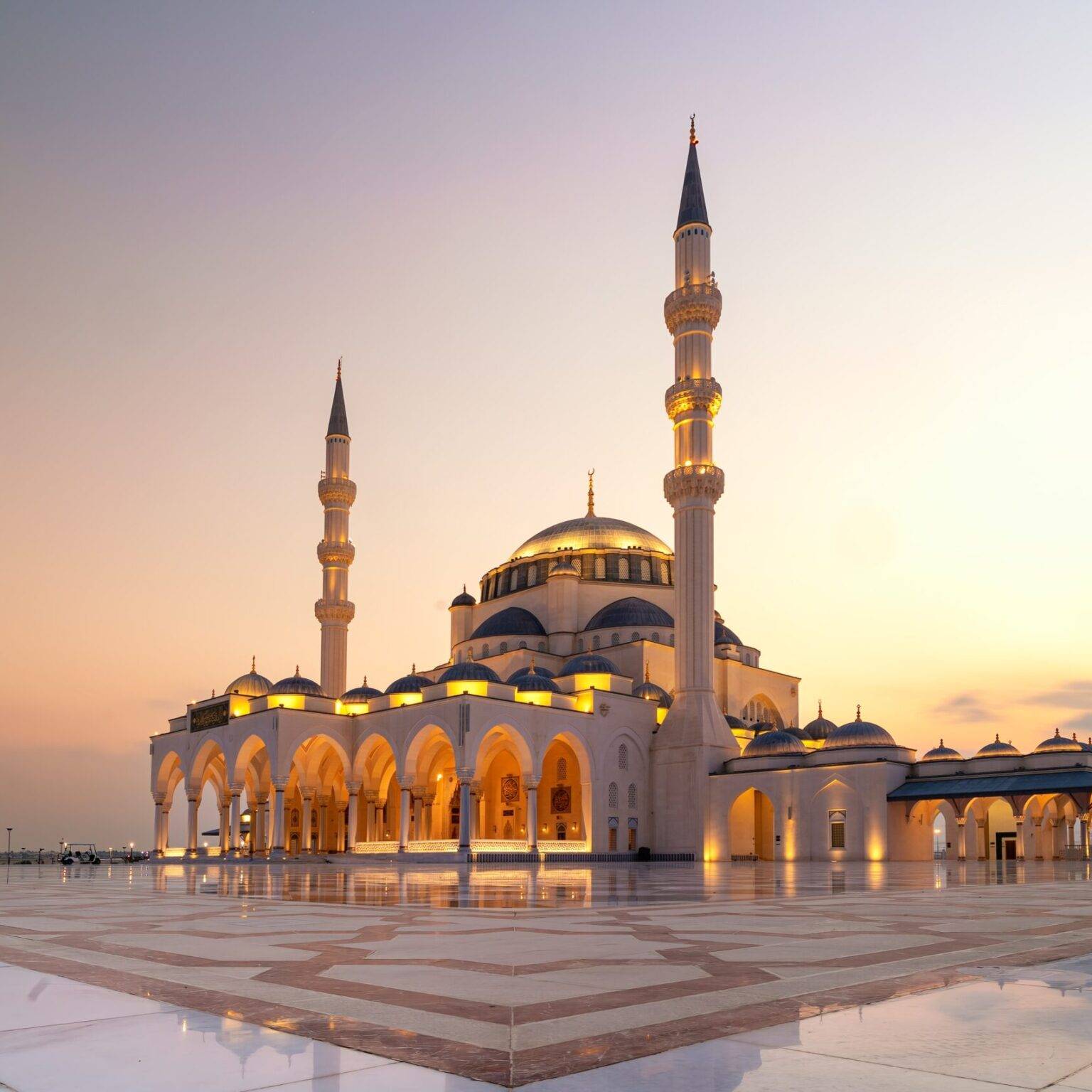 Hinter der Moschee des Emirats Sharjah in den Vereinigten Arabischen Emirate geht die Sonne unter.