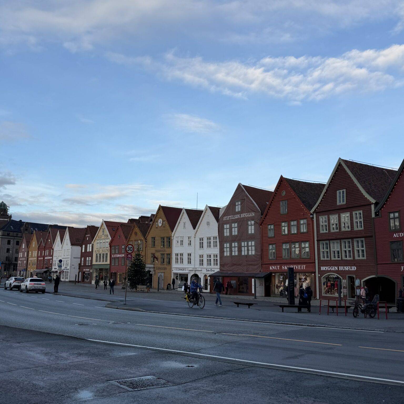 Bunte, historische Gebäude entlang einer Straße unter einem klaren Himmel.