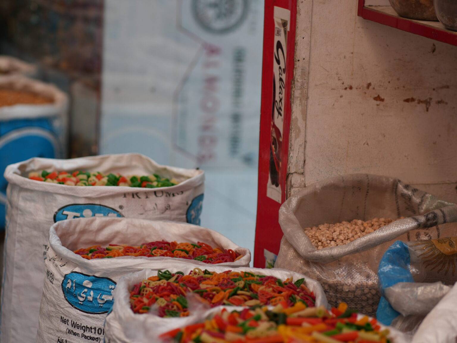 Säcke mit bunten Gewürzen, getrockneten Chilis und Hülsenfrüchten auf einem Stand im Bab Al Bahrain Souk in Manama.