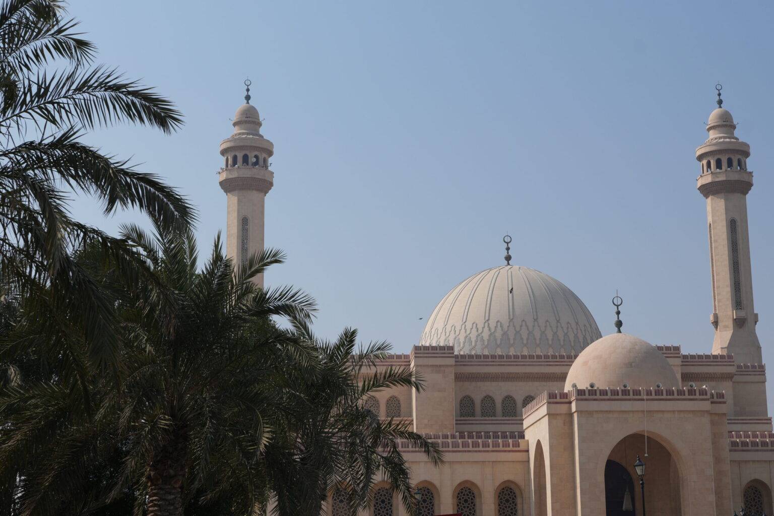 Außenansicht der Al Fateh Grand Mosque in Manama, mit zwei Minaretten und großer Kuppel.