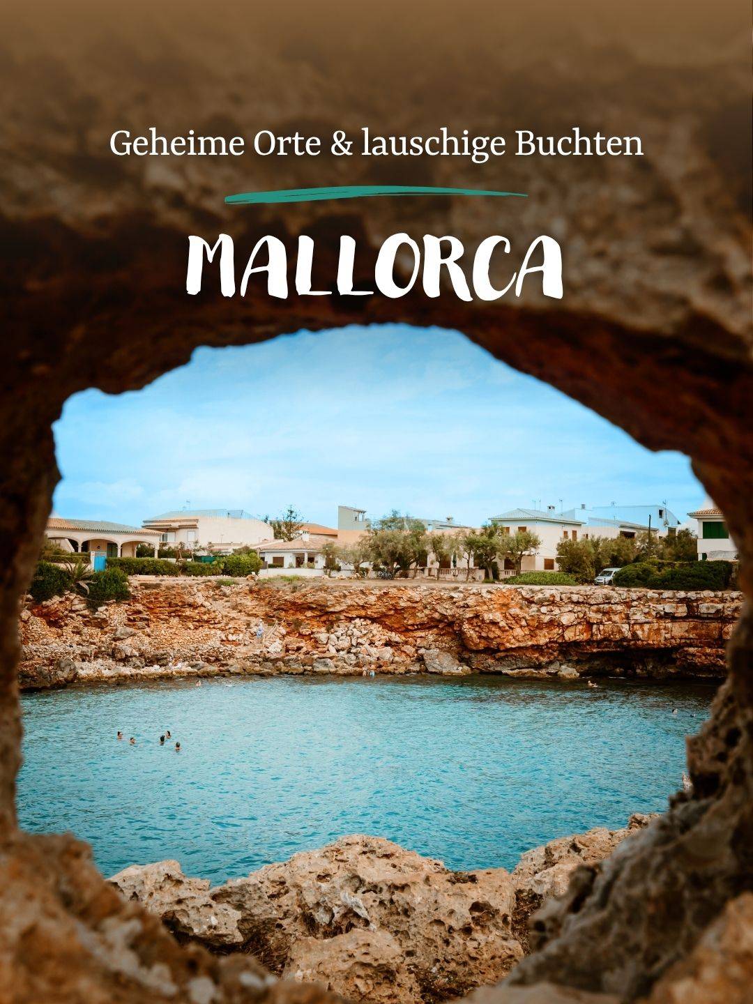 Blick auf eine ruhige Bucht von Mallorca durch eine natürliche Felsöffnung mit Gebäuden im Hintergrund.