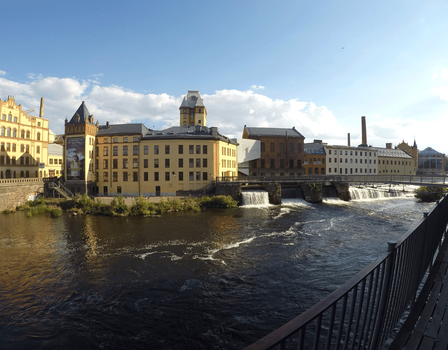 Ein Fluss führt vorbei an alten Indurstriegebäuden in Schwedens Stadt Norrköping.